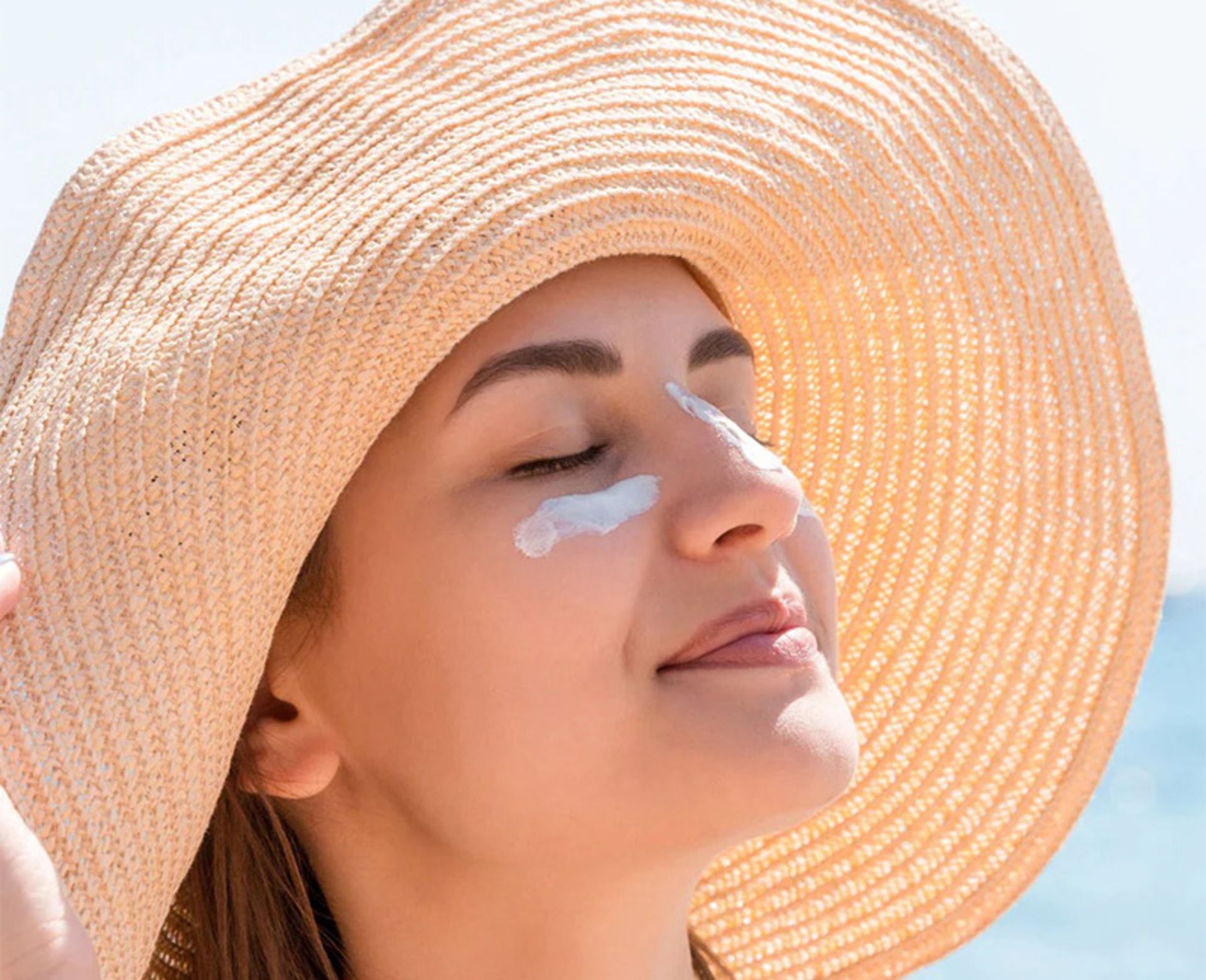 ضدآفتاب روی صورت زنی در ساحل دریا