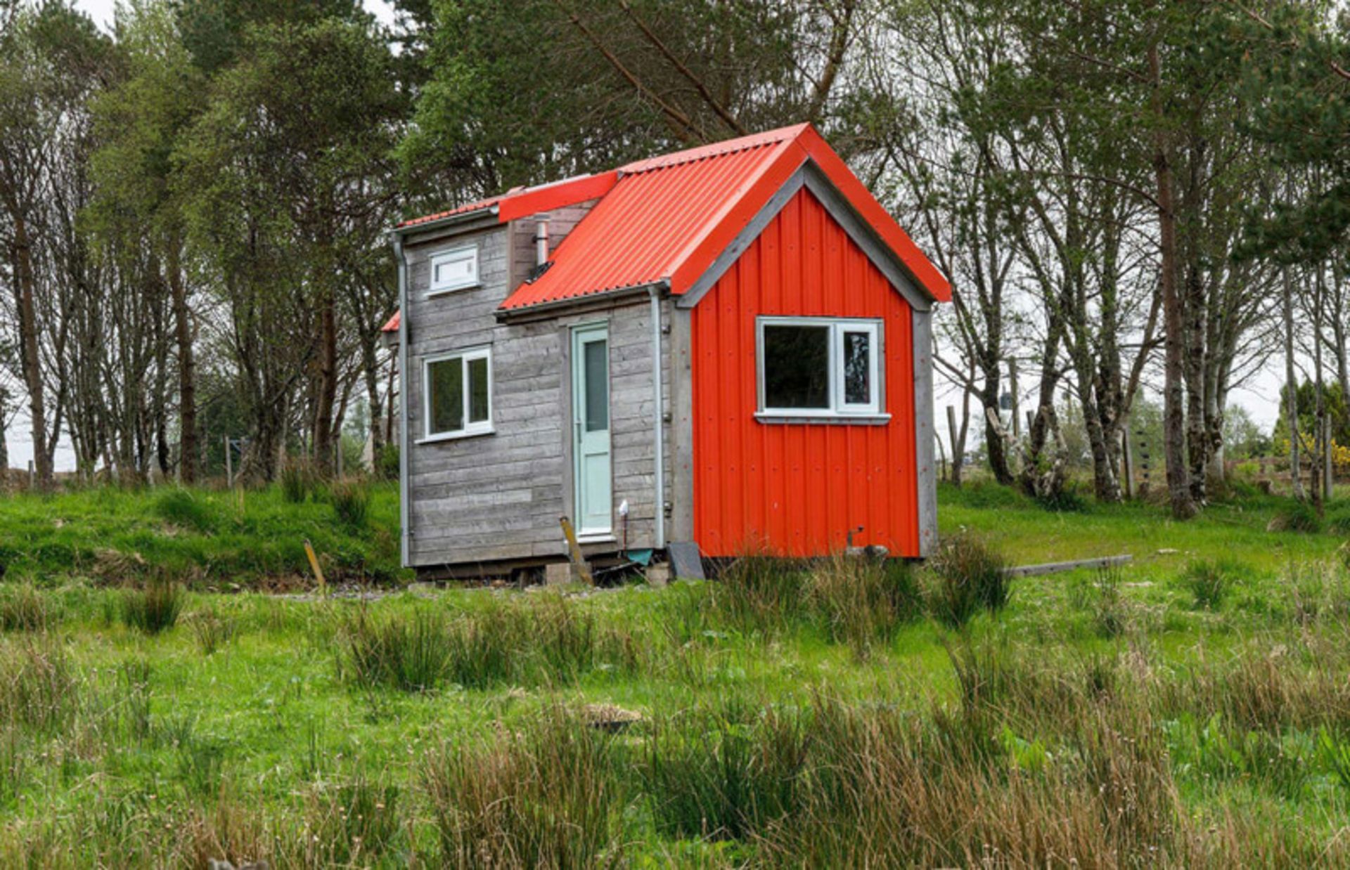 خانه کوچک و مینیمال قرمز رنگ در طبیعت