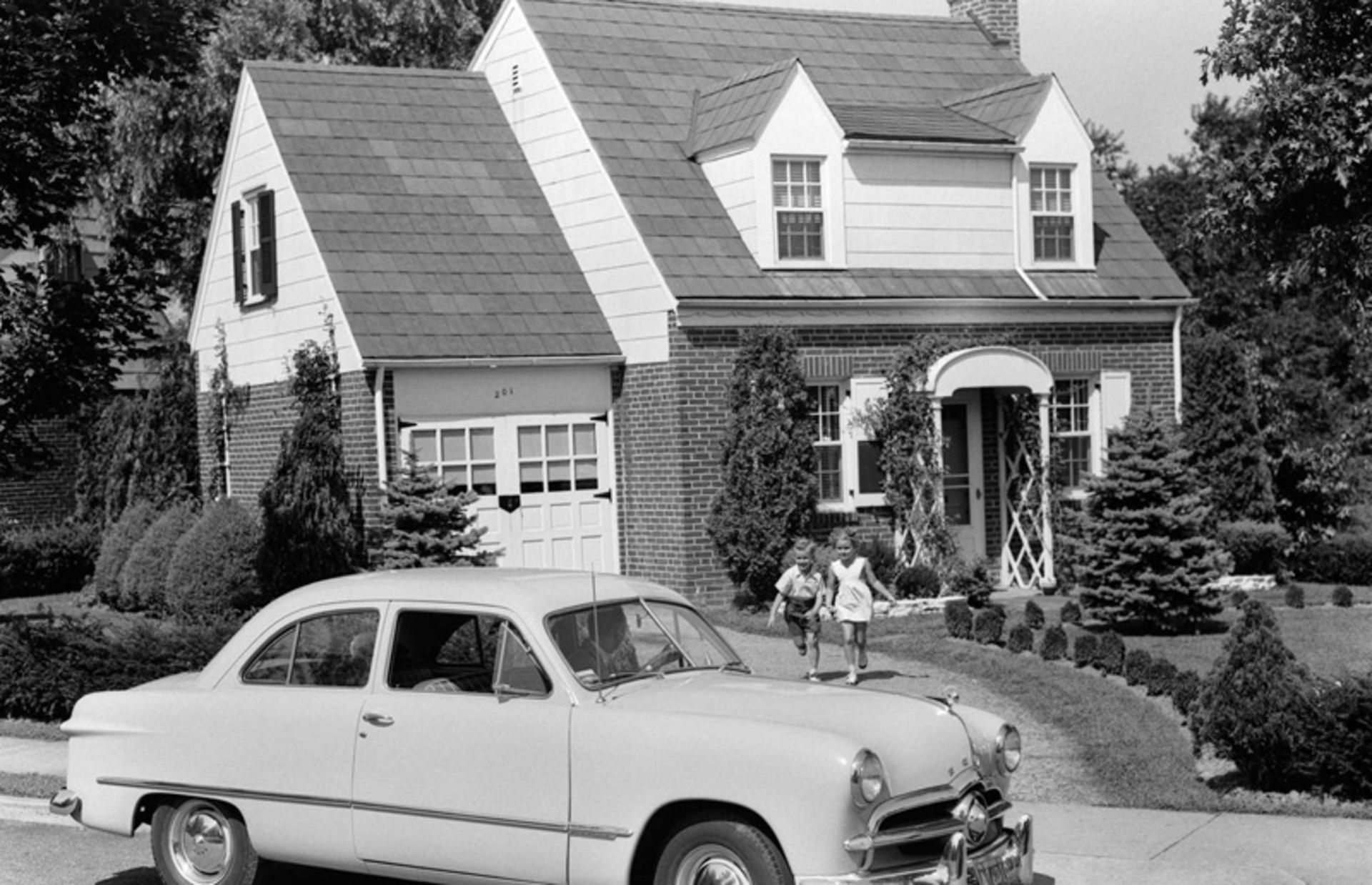 یک خودروی کلاسیک کنار خانه ای در حومه شهر