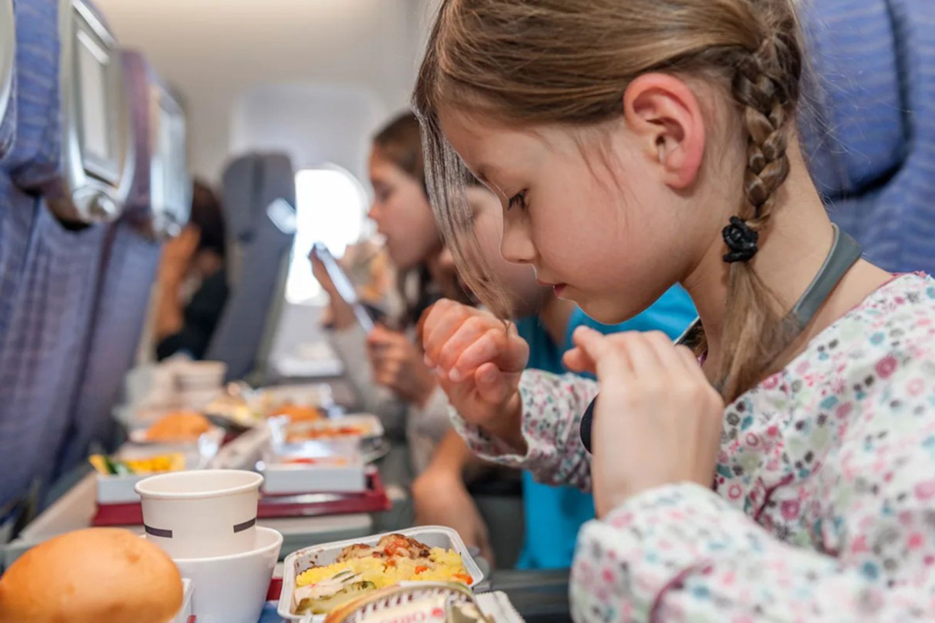 کودک در حال خوردن غذای هواپیما