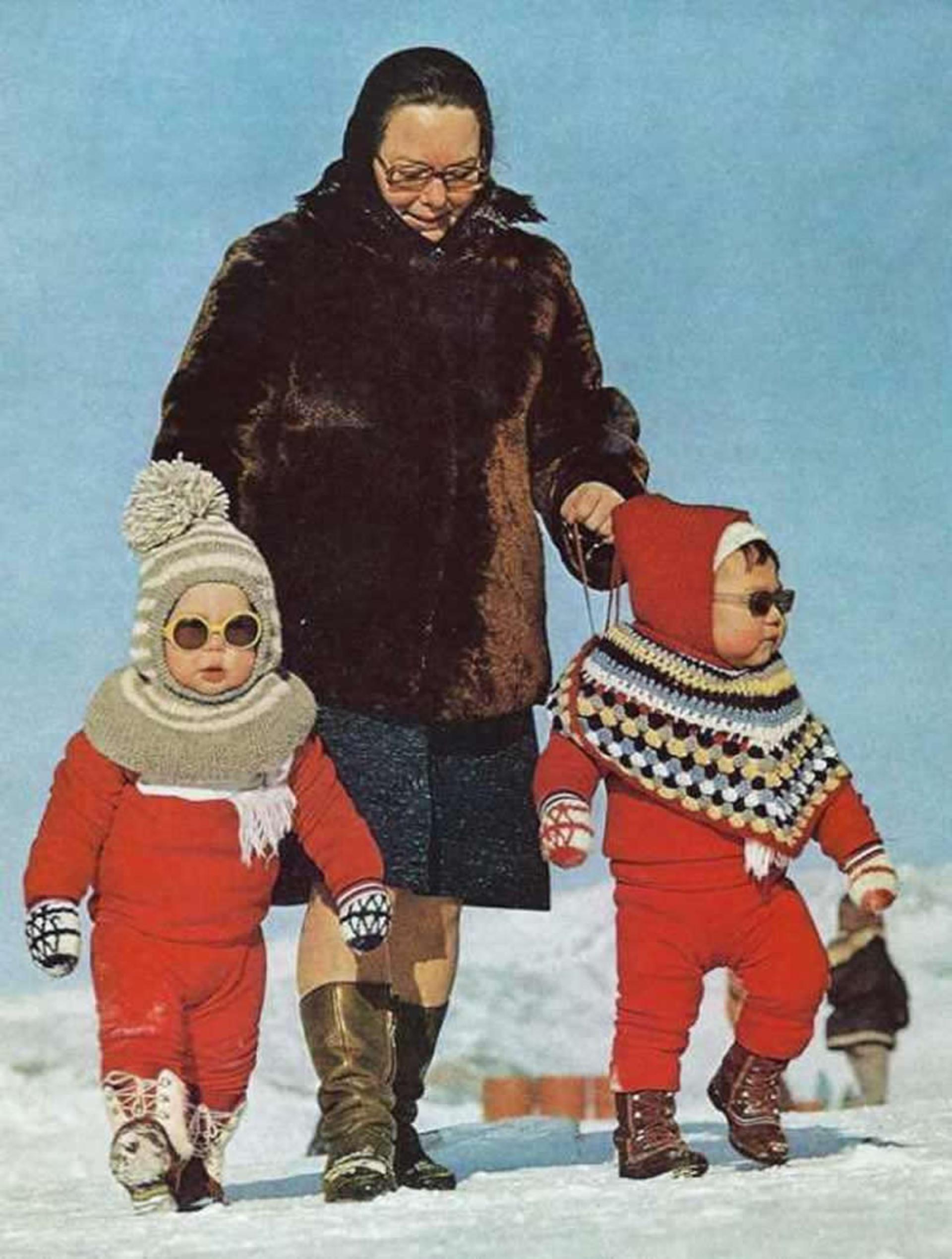 دو کودک نوپای بامزه در حال پیاده‌روی با مادربزرگشان. گرینلند، ۱۹۷۳