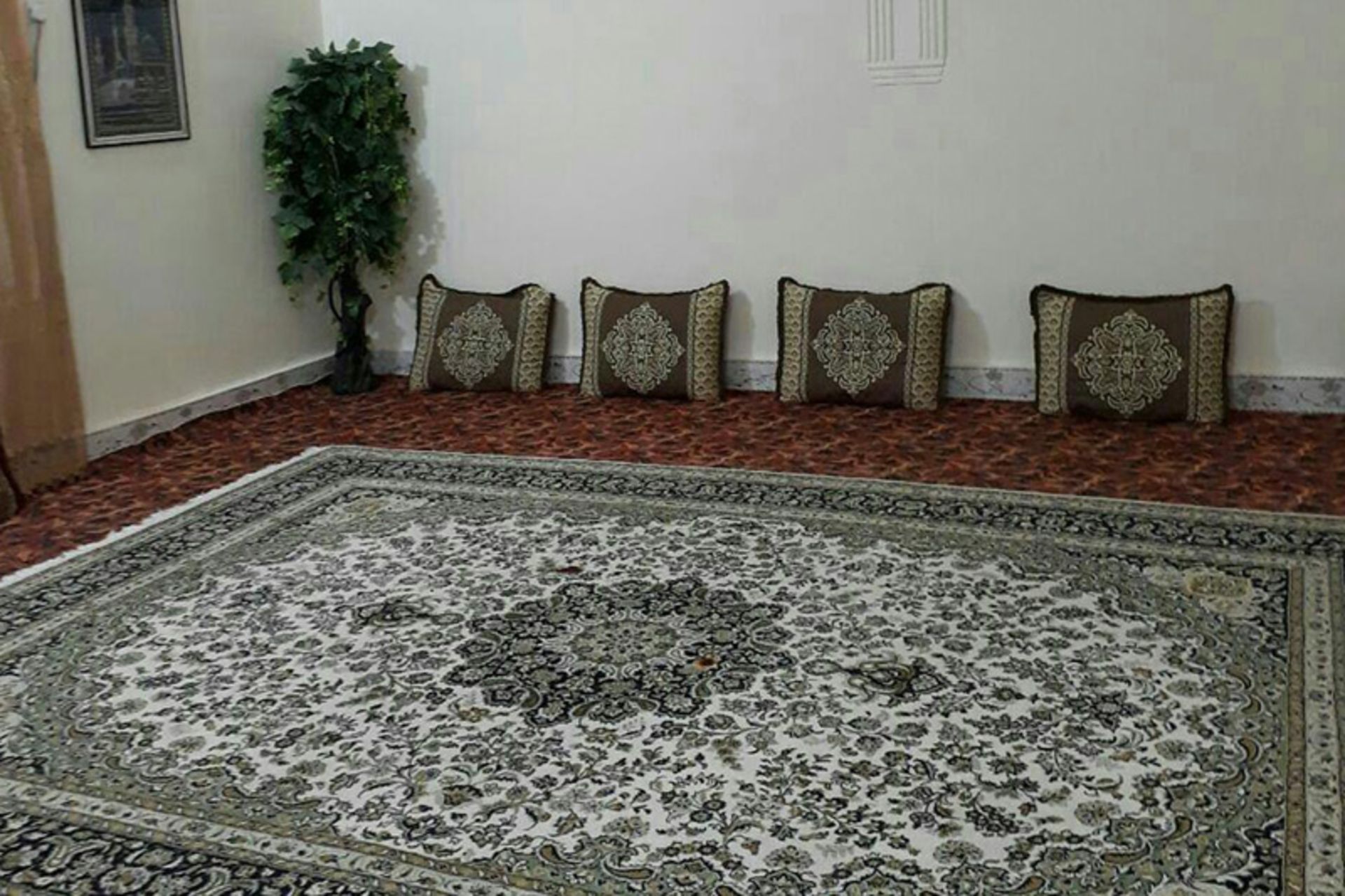 اتاقی سنتی با ردیف پشتی‌ها در اقامتگاه بوم‌گردی و موزه ناخدا علی در لافت