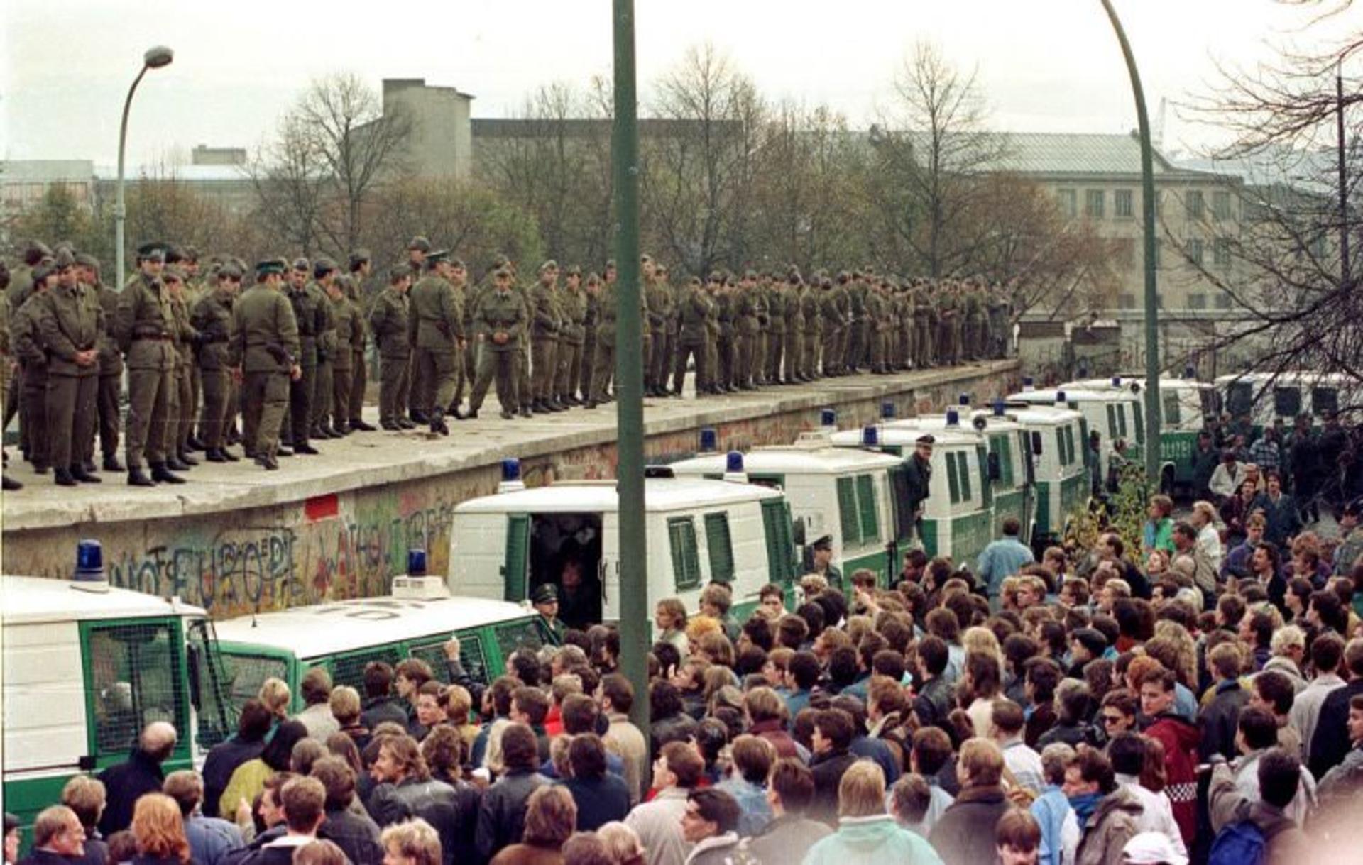 2015-11-looking-out-onto-a-sea-of-thousands-east-berlin-border-guards-stood-atop-the-berlin-wall-at-the-brandenburg-gate-november-11