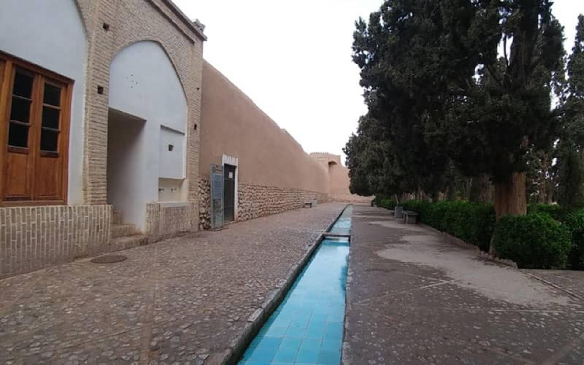 جوی آبی با کاشی های فیروزه ای در مقابل دیواری قدیمی
