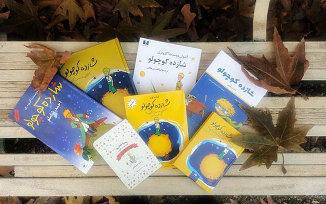 کتاب شازده کوچولو روی نیمکت پاییزی