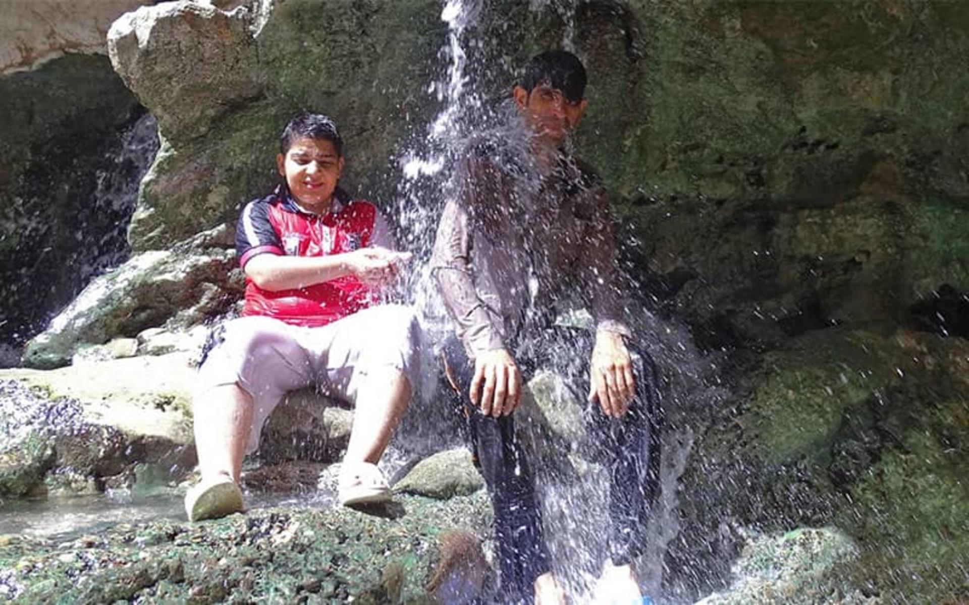 گردشگران چشمه مرتضی علی در زیر جریان آب