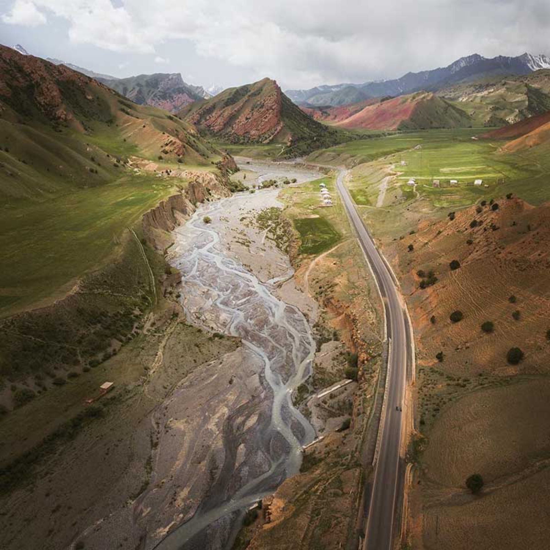 چادرهای روستایی برپا شده در کنار یک جاده‌ی کوهستانی؛ قرقیزستان