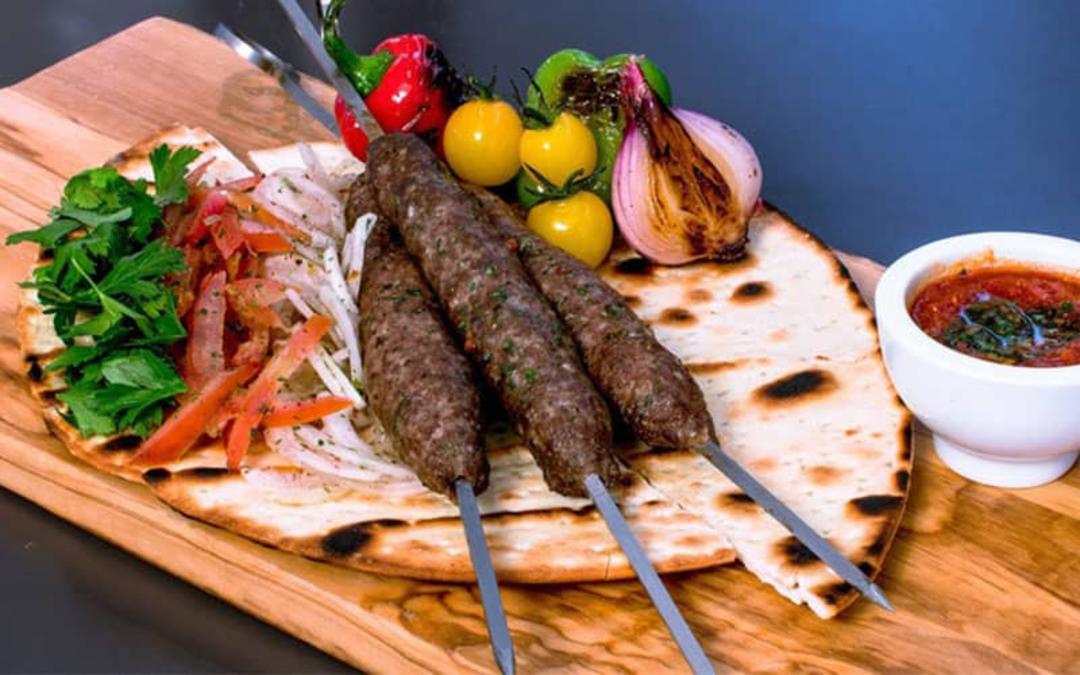 سه سیخ کباب روی نان تازه با گوجه و پیاز