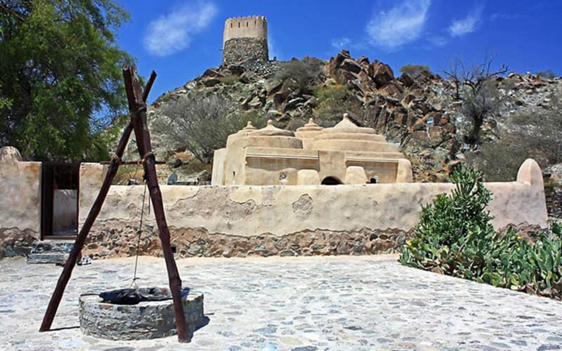 ساختمانی سنگی با یک برج و چاهی در وسط آن