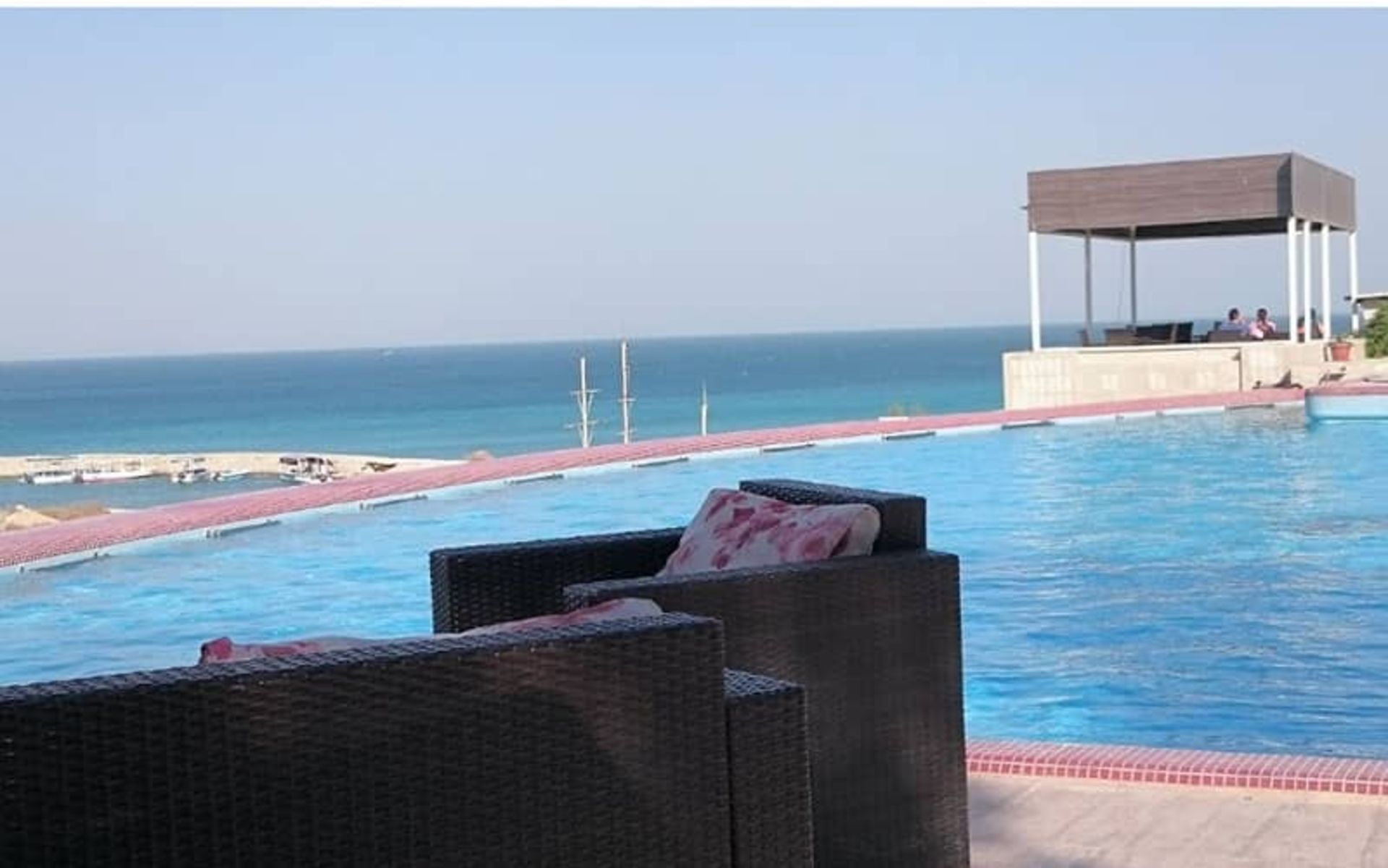 مبلمان راحتی در کنار استخری مشرف به دریا