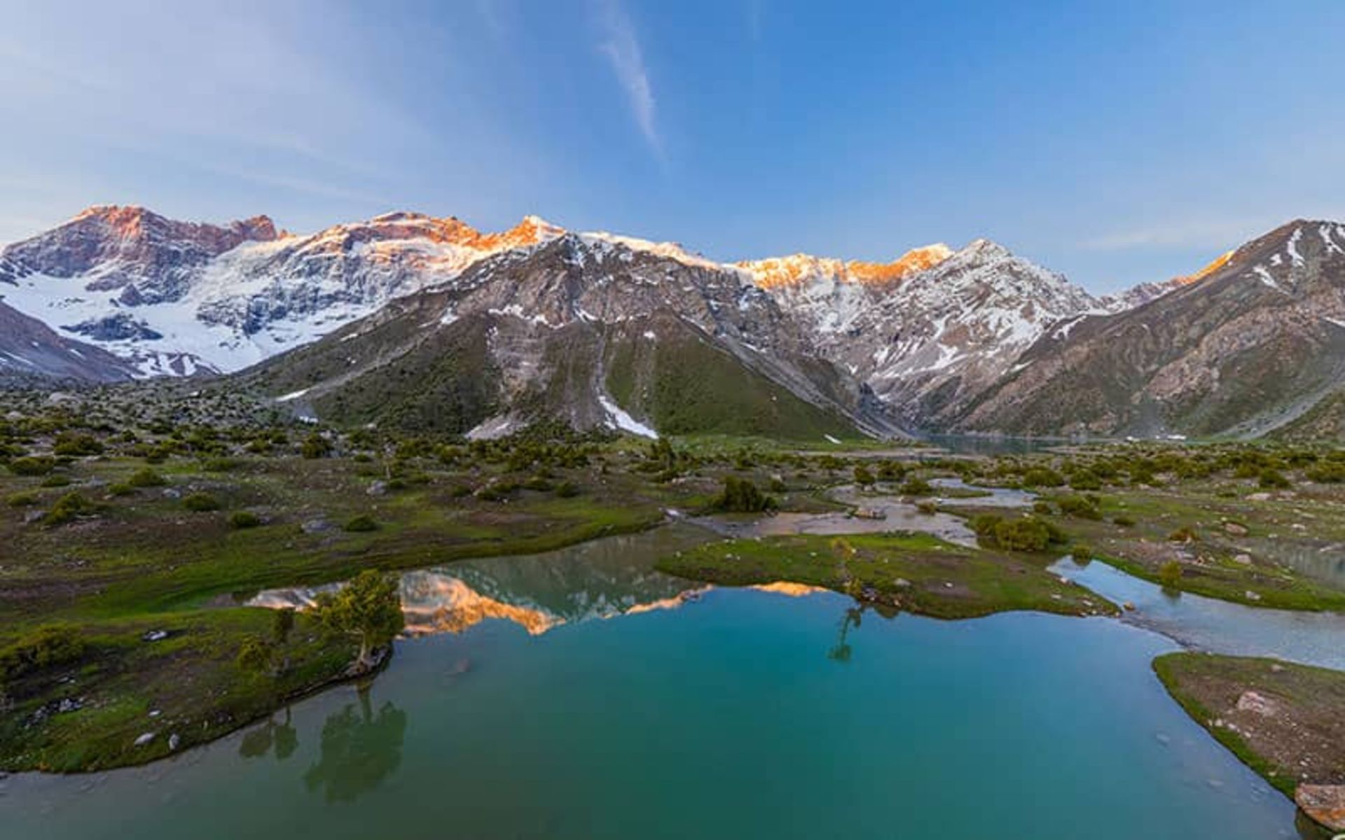 دریاچه ای در کنار کوهستان و انعکاس کوهها در آب