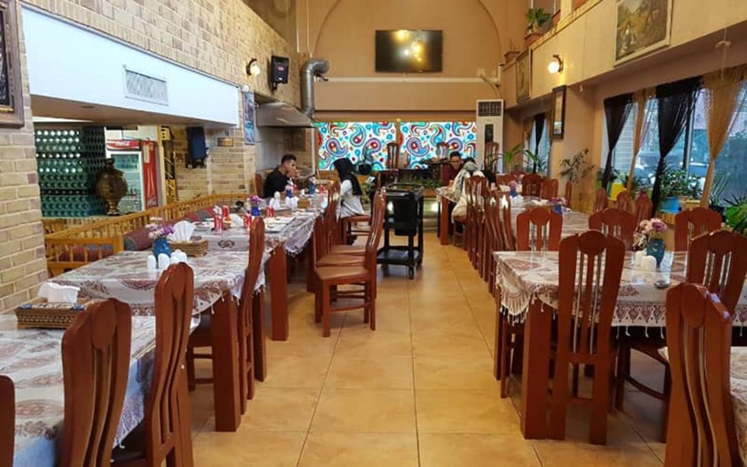 رستورانی خلوت با کف سرامیک و صندلی های چوبی