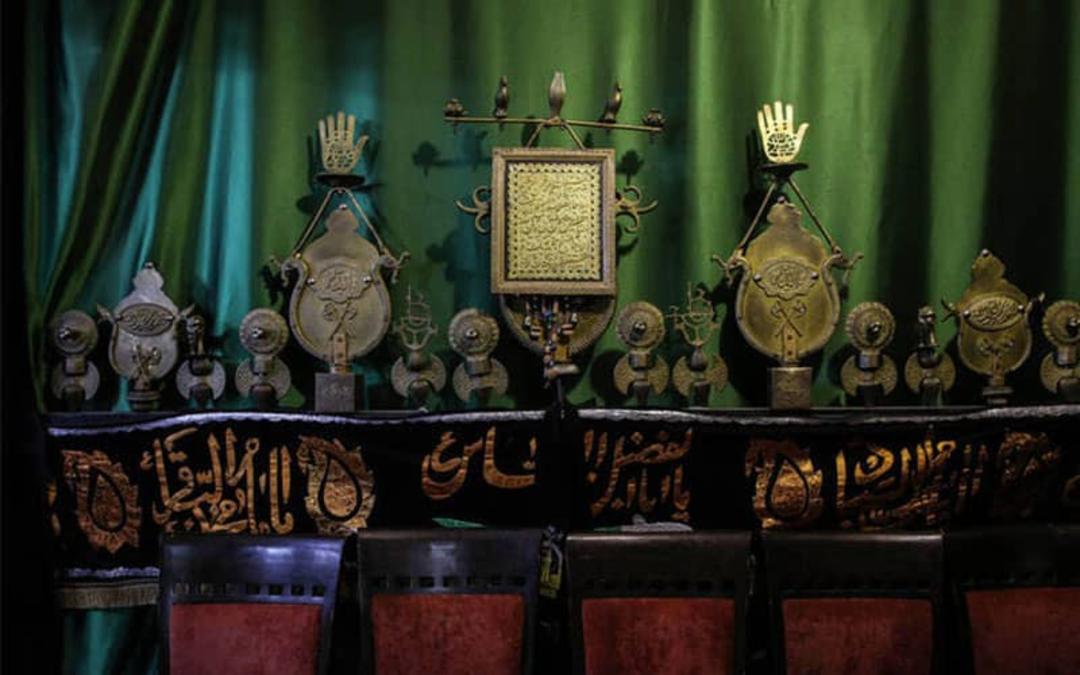 علم عزاداری امام حسین و پرده ای سبز پشت آن