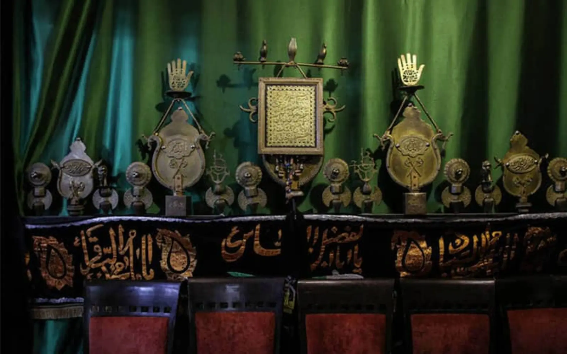 علم عزاداری امام حسین و پرده ای سبز پشت آن