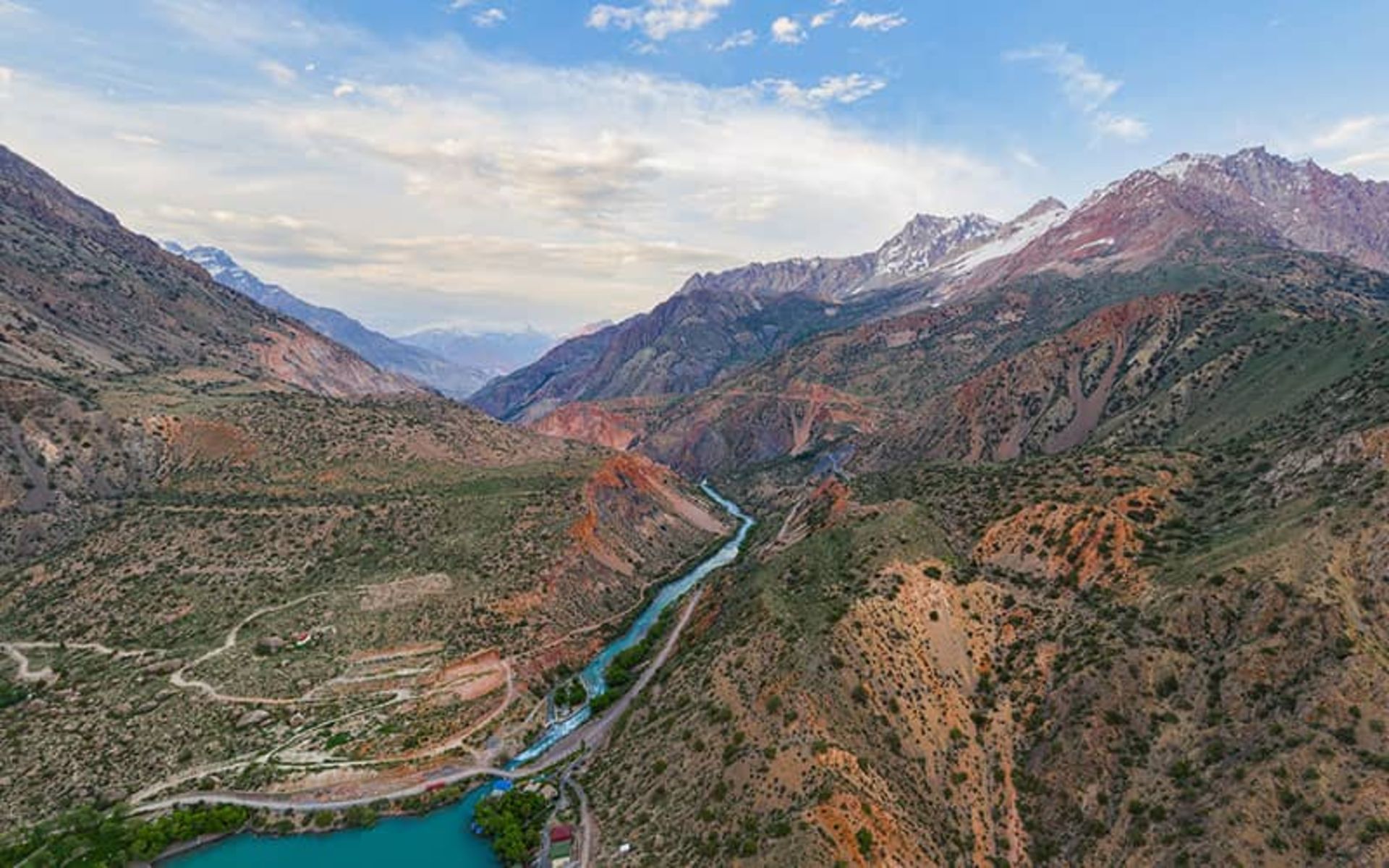 رودخانه ای باریک و آبی رنگ در وسط کوهستان