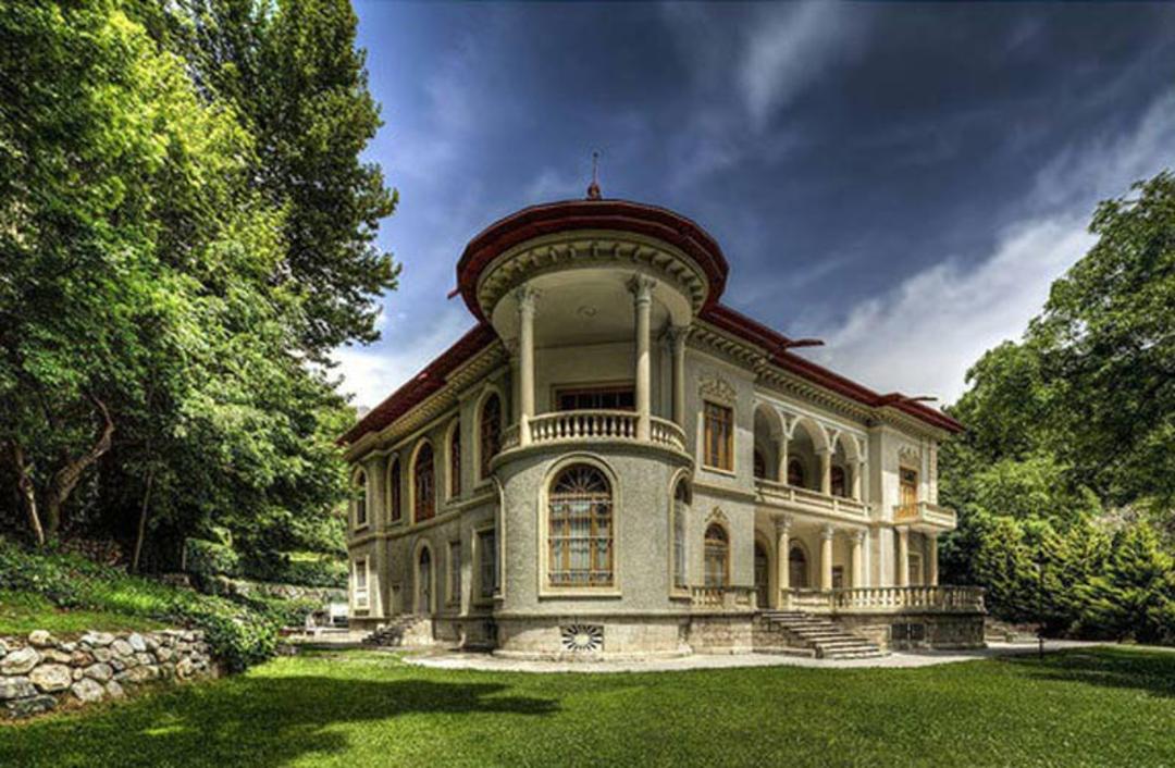 نمایی از کاخ سعد آباد در میان درختان و سبزه‌ زار