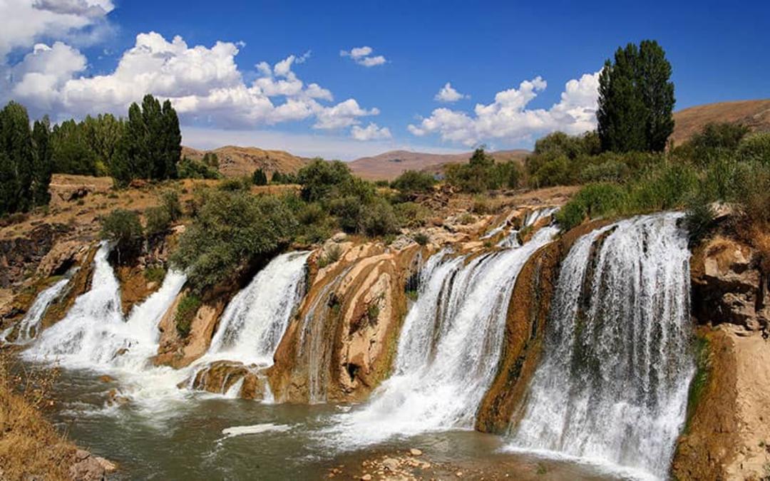 آبشاری با ارتفاع کم در منطقه ای سرسبز