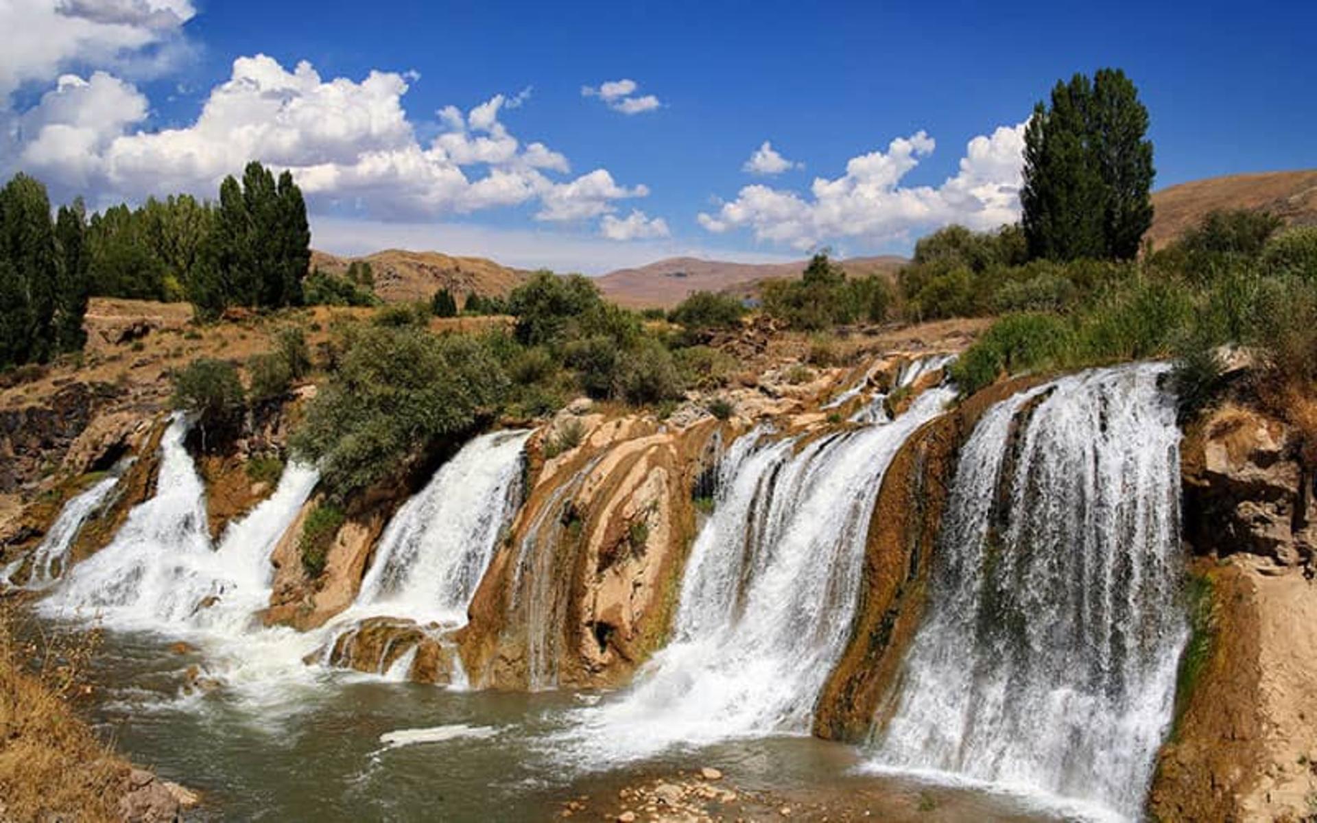 آبشاری با ارتفاع کم در منطقه ای سرسبز