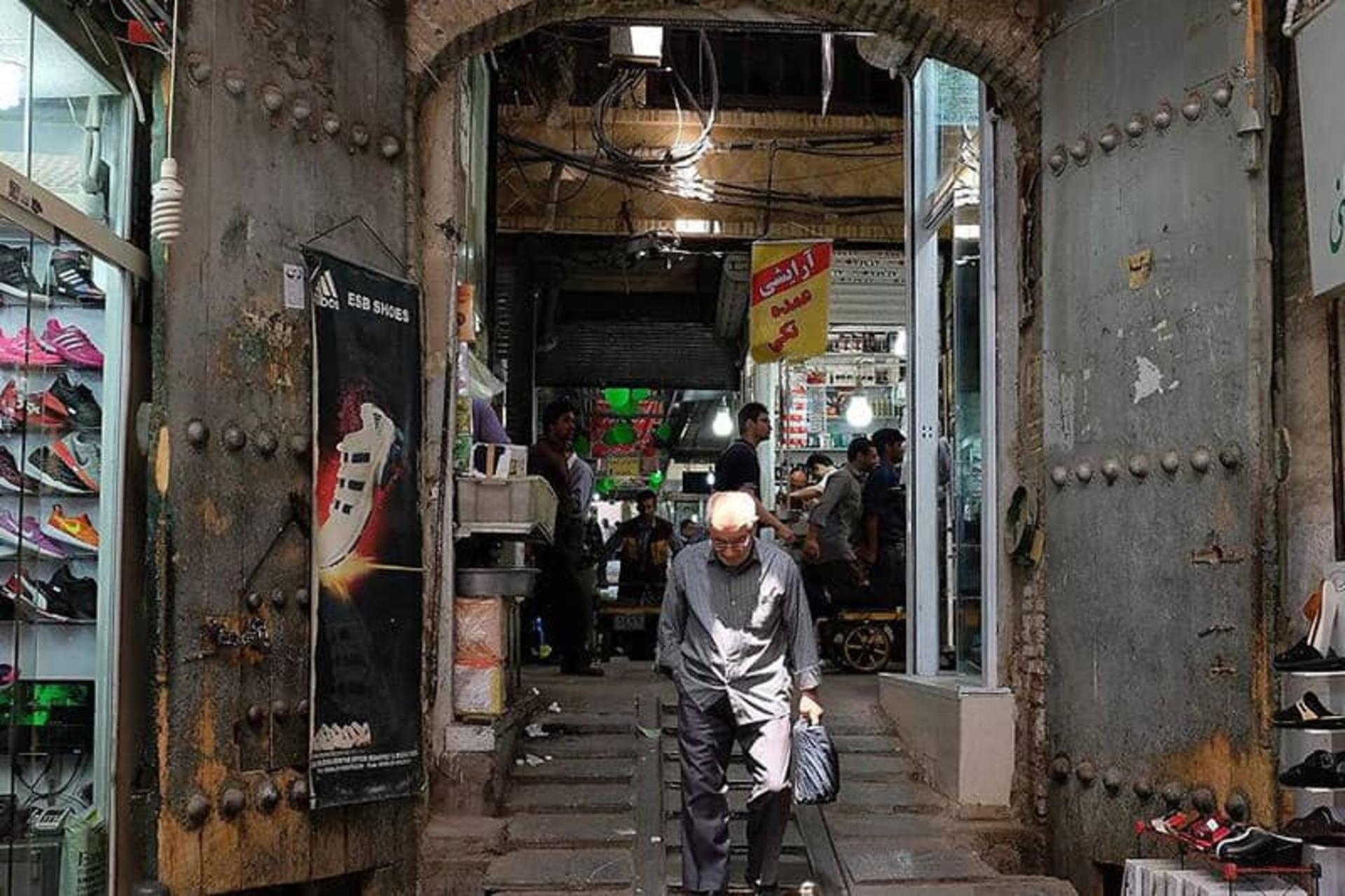 پیرمردی در حال پایین آمدن از پله های بازار