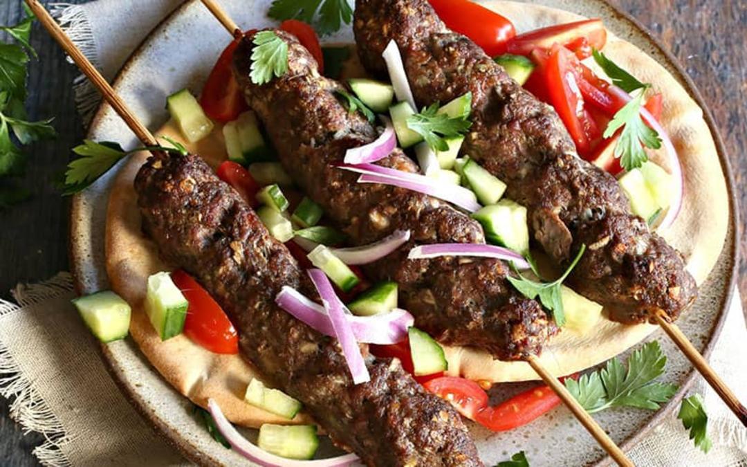 سه سیخ کباب آدنا همراه با پیاز و خیار و گوجه خرد شده