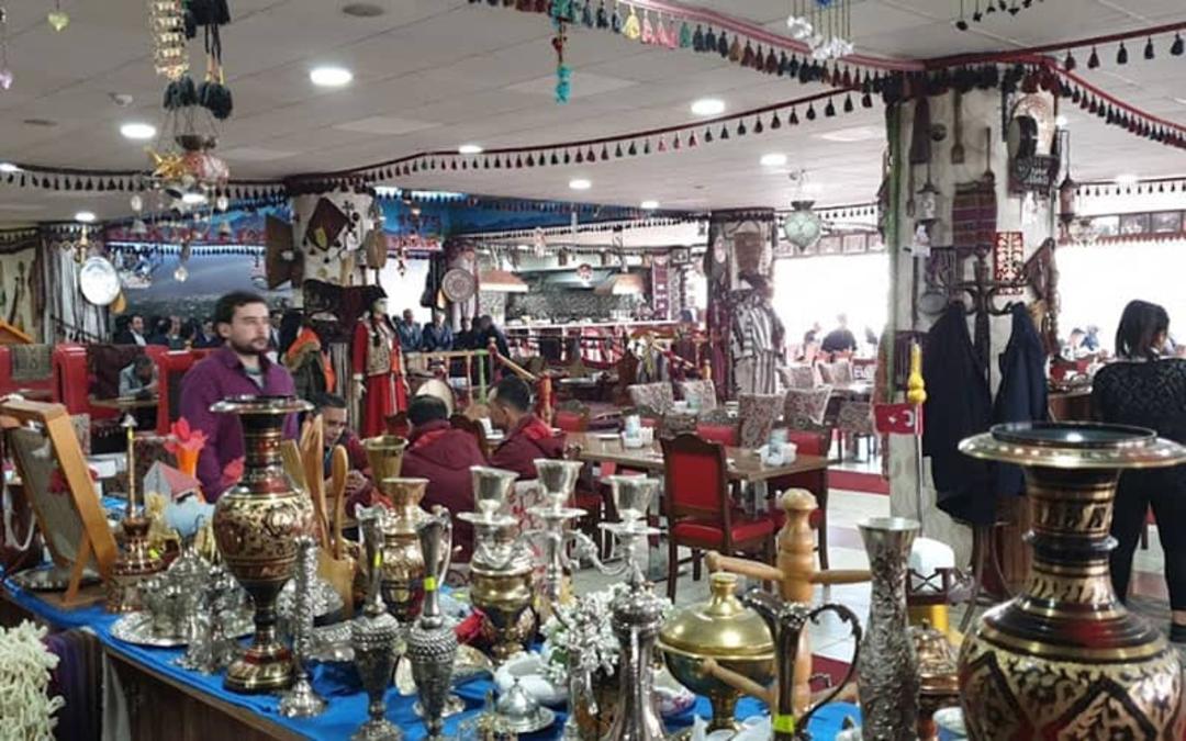 رستورانی سنتی با میزی پر از وسایل عتیقه