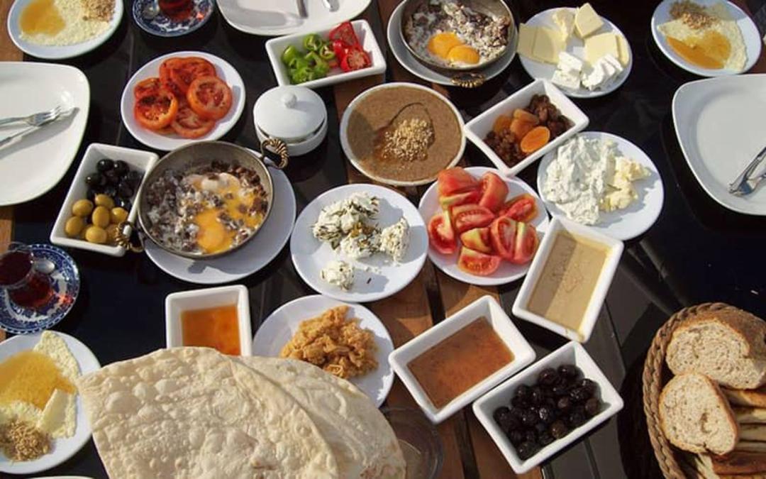 یک میز بزرگ صبحانه با انواع و اقسام خوراکی ها