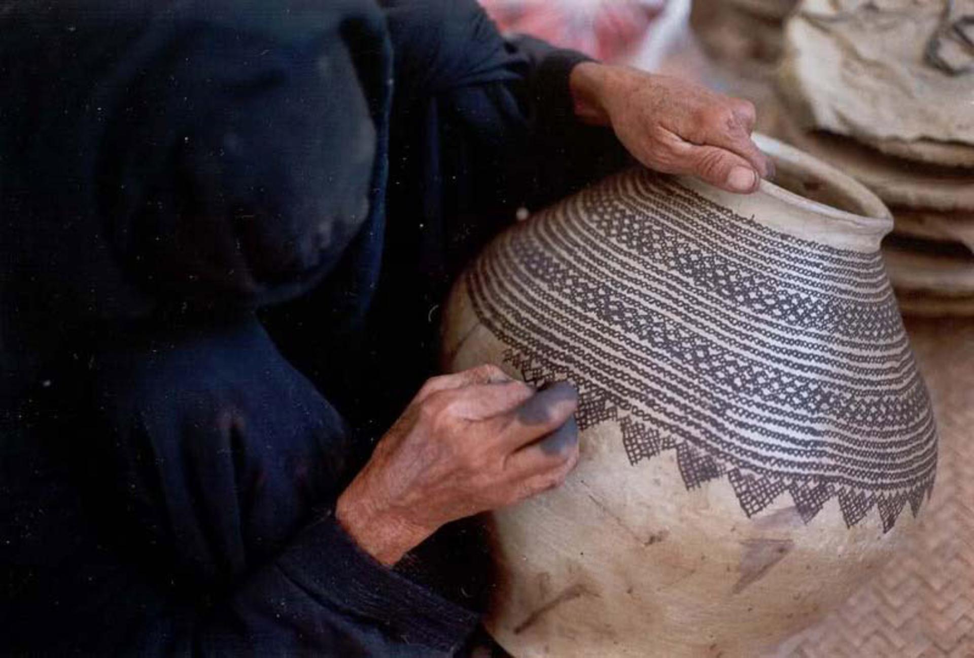زن بلوچ در حال نقاشی سفال کلپورگان