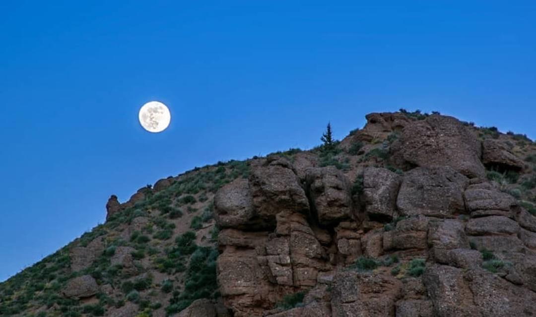 کوه انار زیر تصویر ماه زیر آسمان آبی