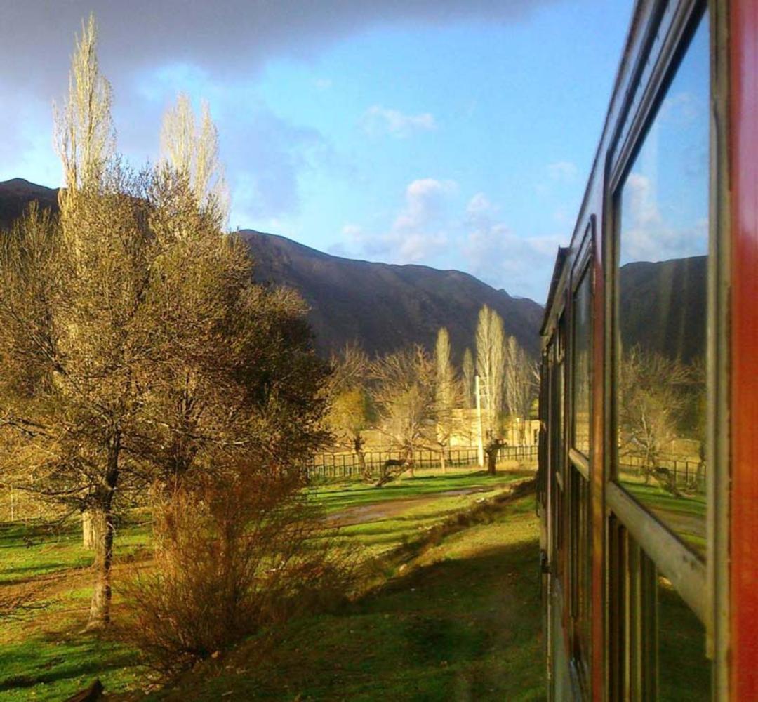 درختان پاییزی در جوار خانه های روستای سیمین دشت زیر آسمان آبی
