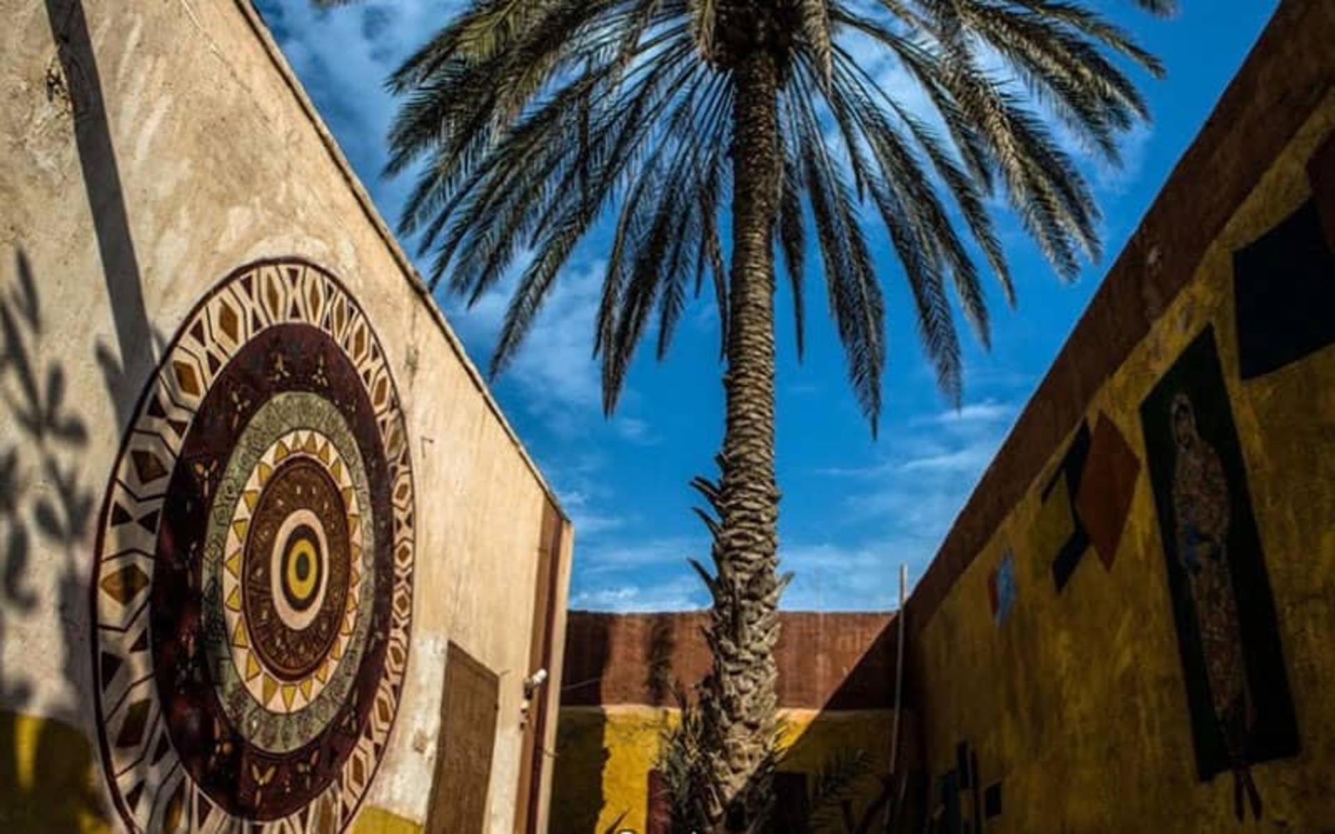 دیوارهای منقوش و نخلی در وسط حیاط موزه
