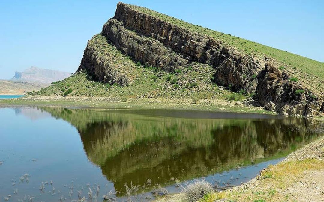 تپه ای سرسبز و مرتفع در کنار دریاچه سد درودزن