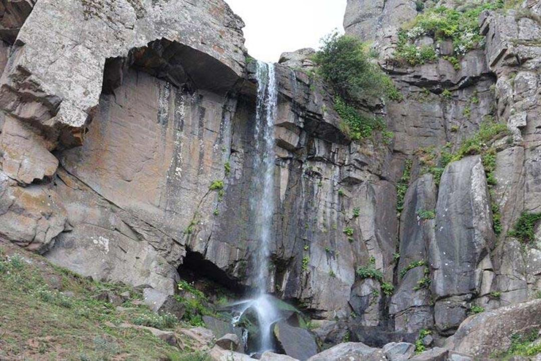 نمایی از آبشار ورزان در سوباتان از دور میان صخره ها
