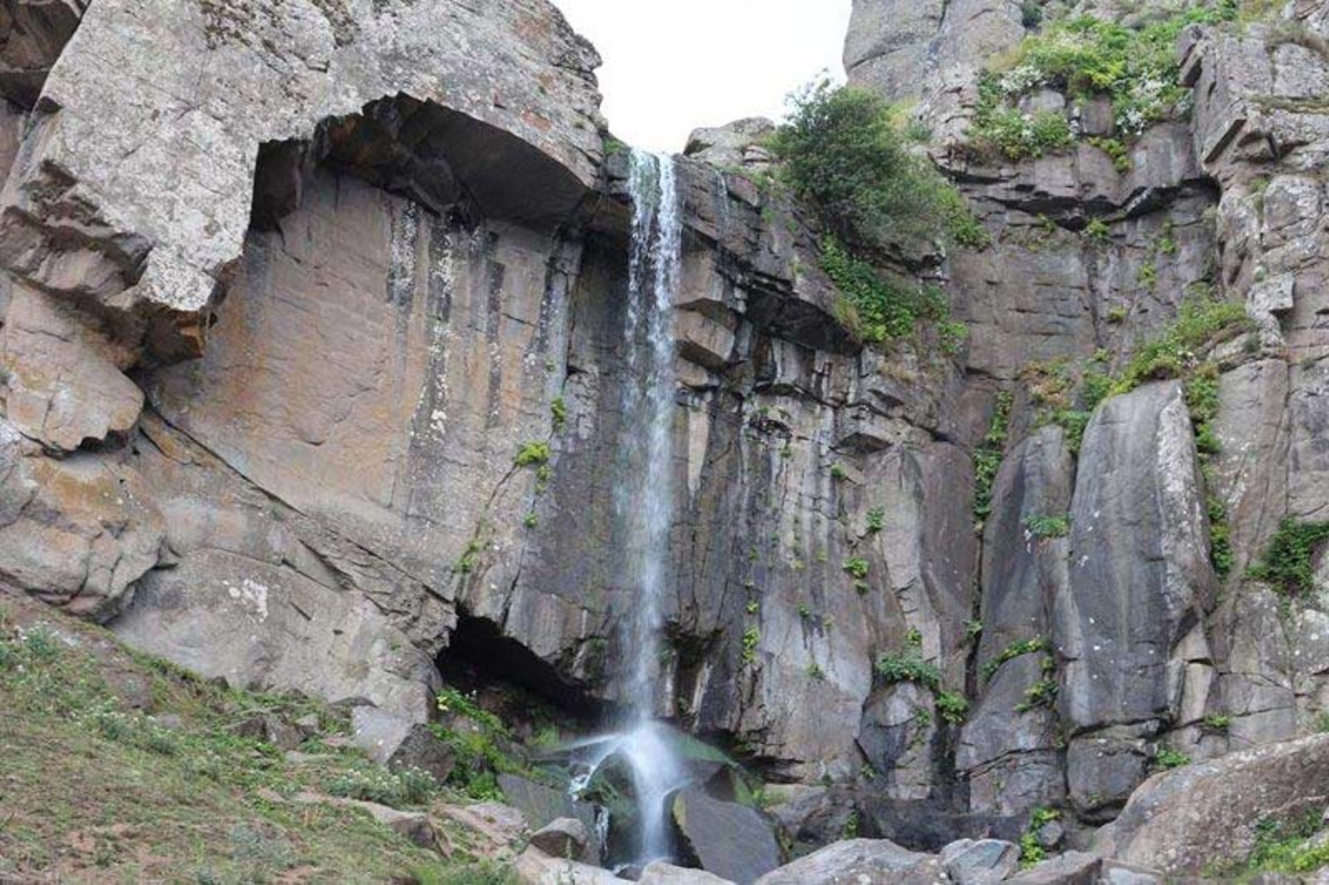 نمایی از آبشار ورزان در سوباتان از دور میان صخره ها
