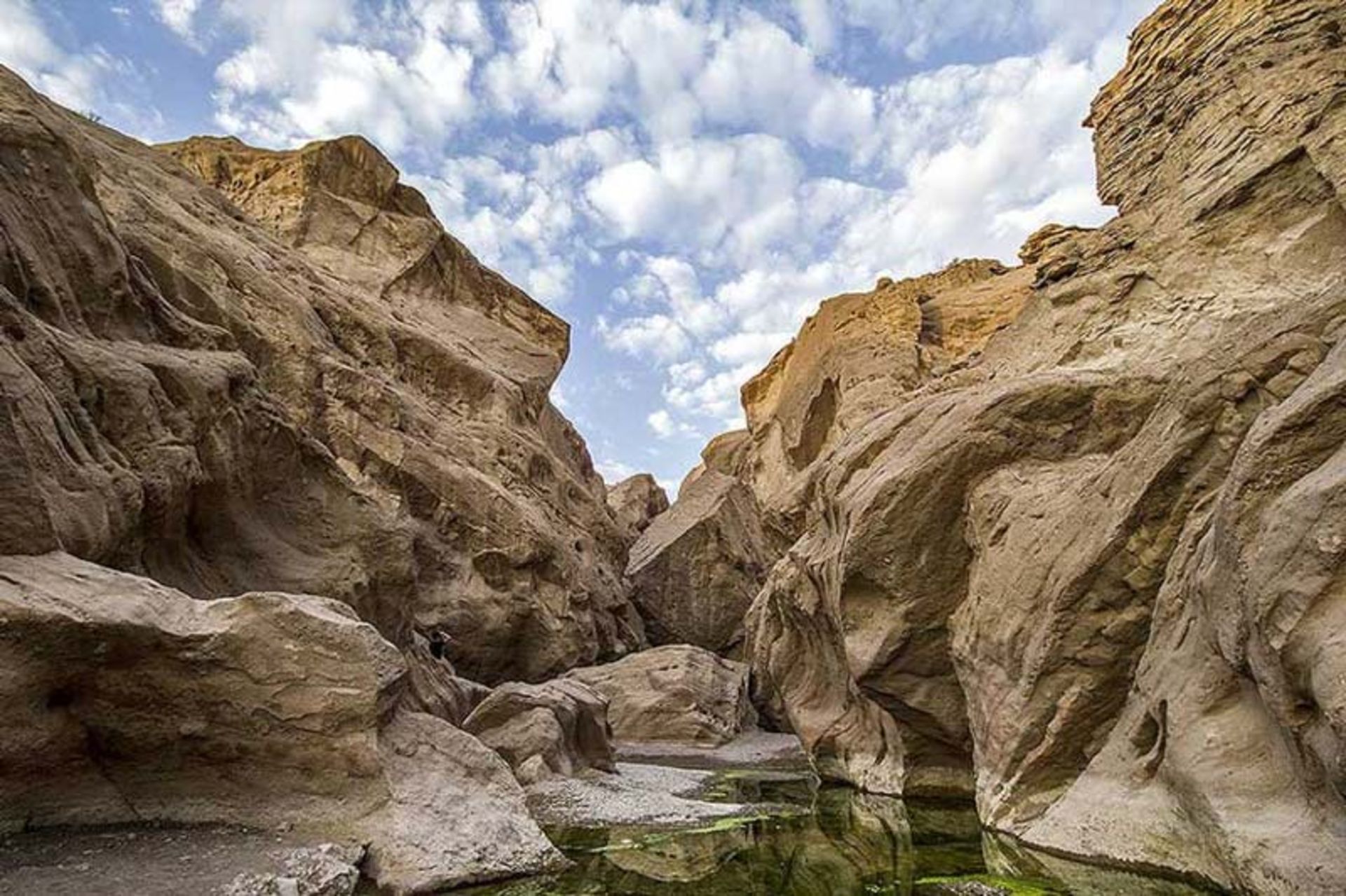 صخره های زیبای تنگه راگه زیر آسمان آبی پر ابر