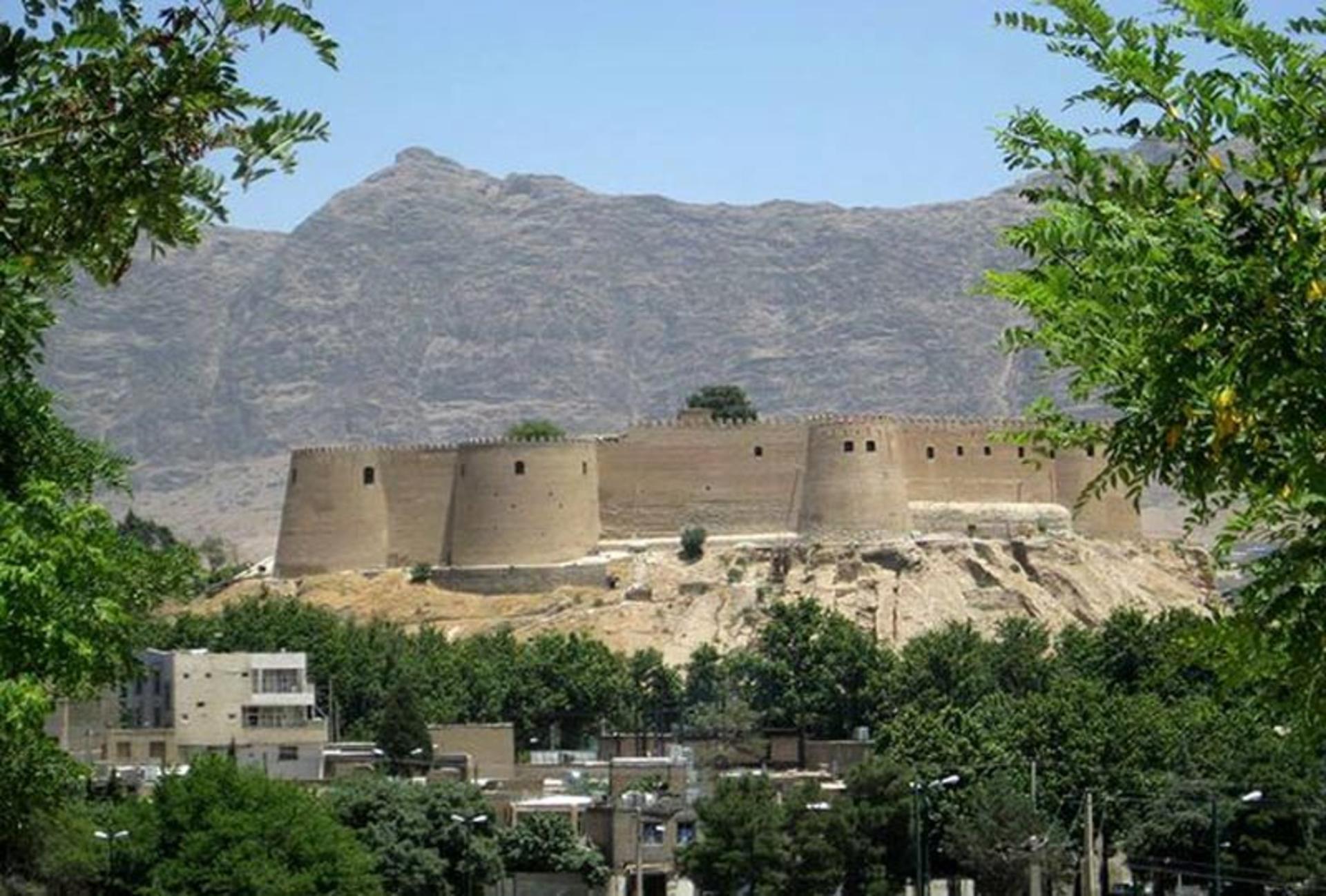 نمایی از قلعه فلک الافلاک میان درختان سبز از نمای دور