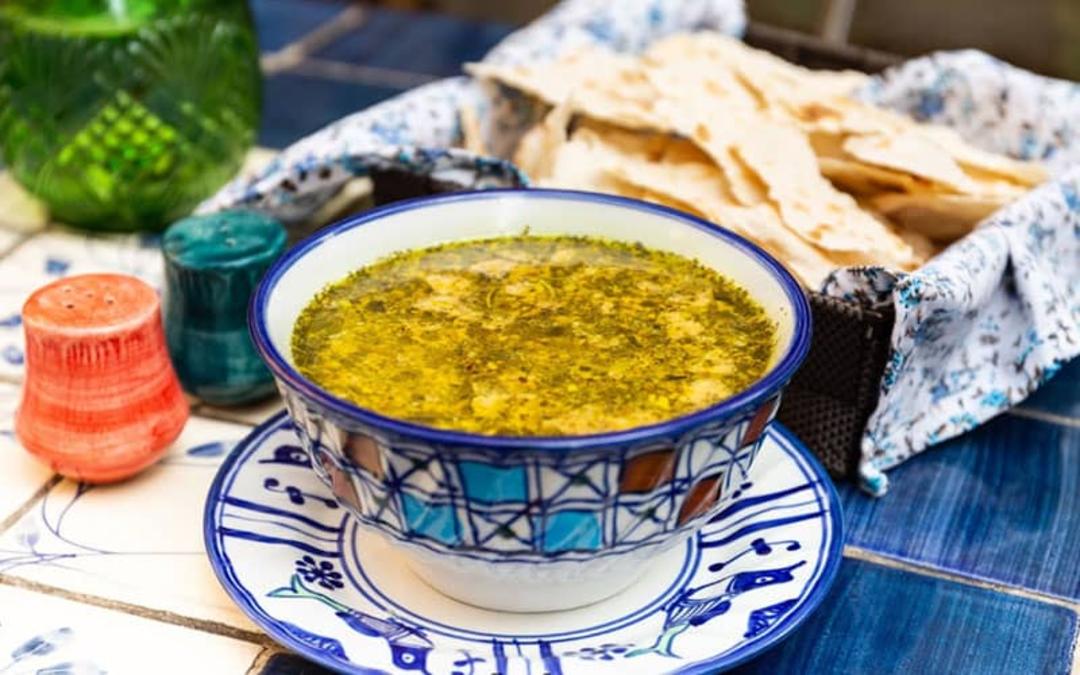 یک کاسه آش در کنار نان در کافه مانا