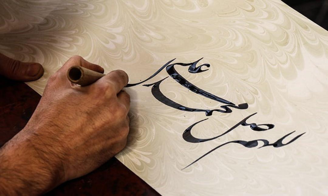هنرمند خوشنویسی در حال خطاطی