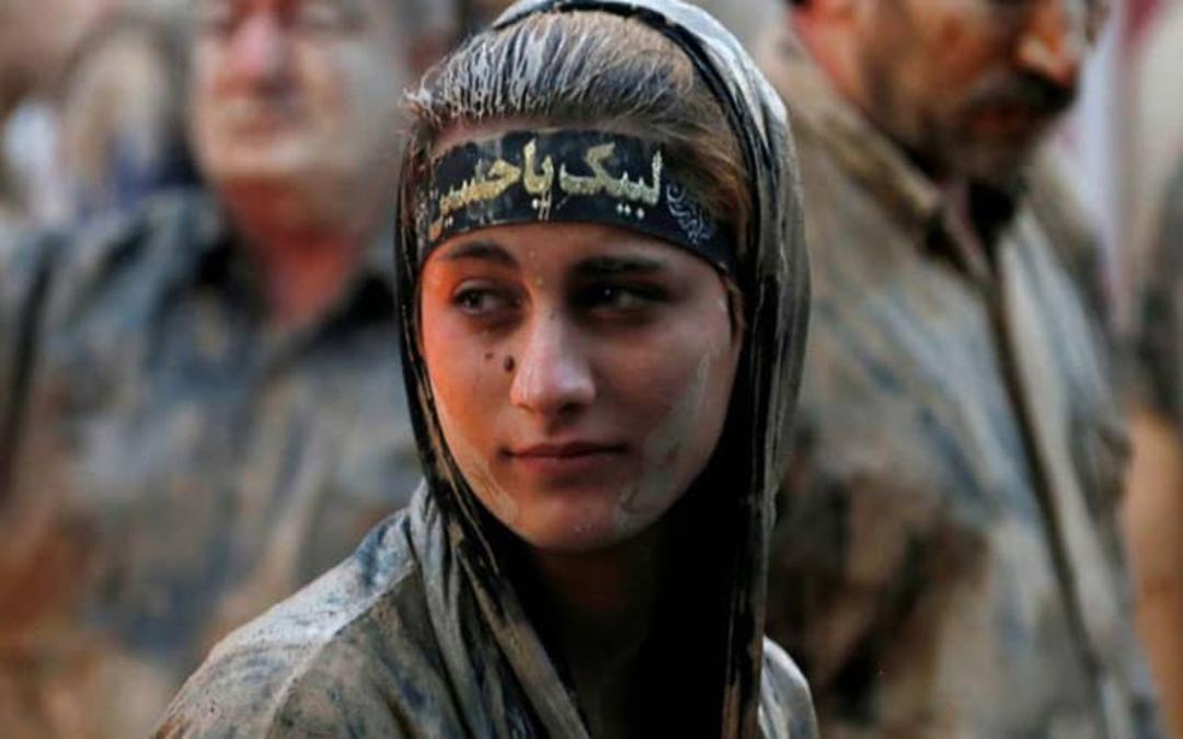 دختری با سر و صورت گلی و سربند لبیک یا حسین