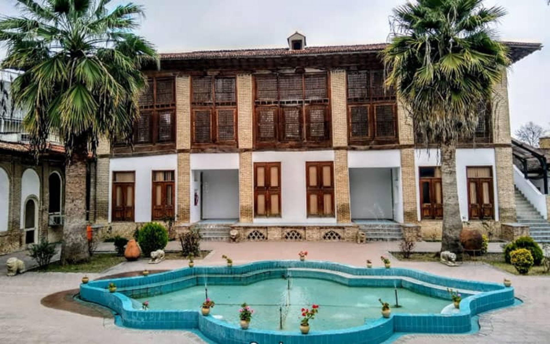 خانه دو طبقه قدیمی با حوض آبی در حیاطش