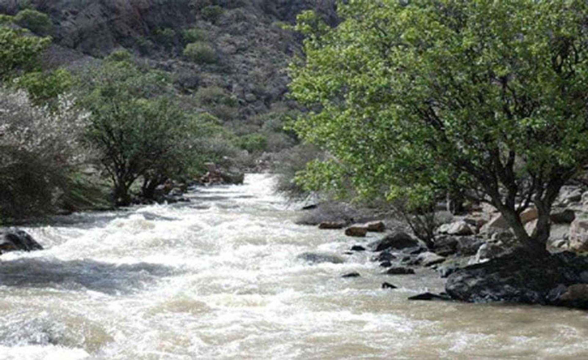 رودخانه پارک ملی بختگان در جوار درختان سبز و کوه