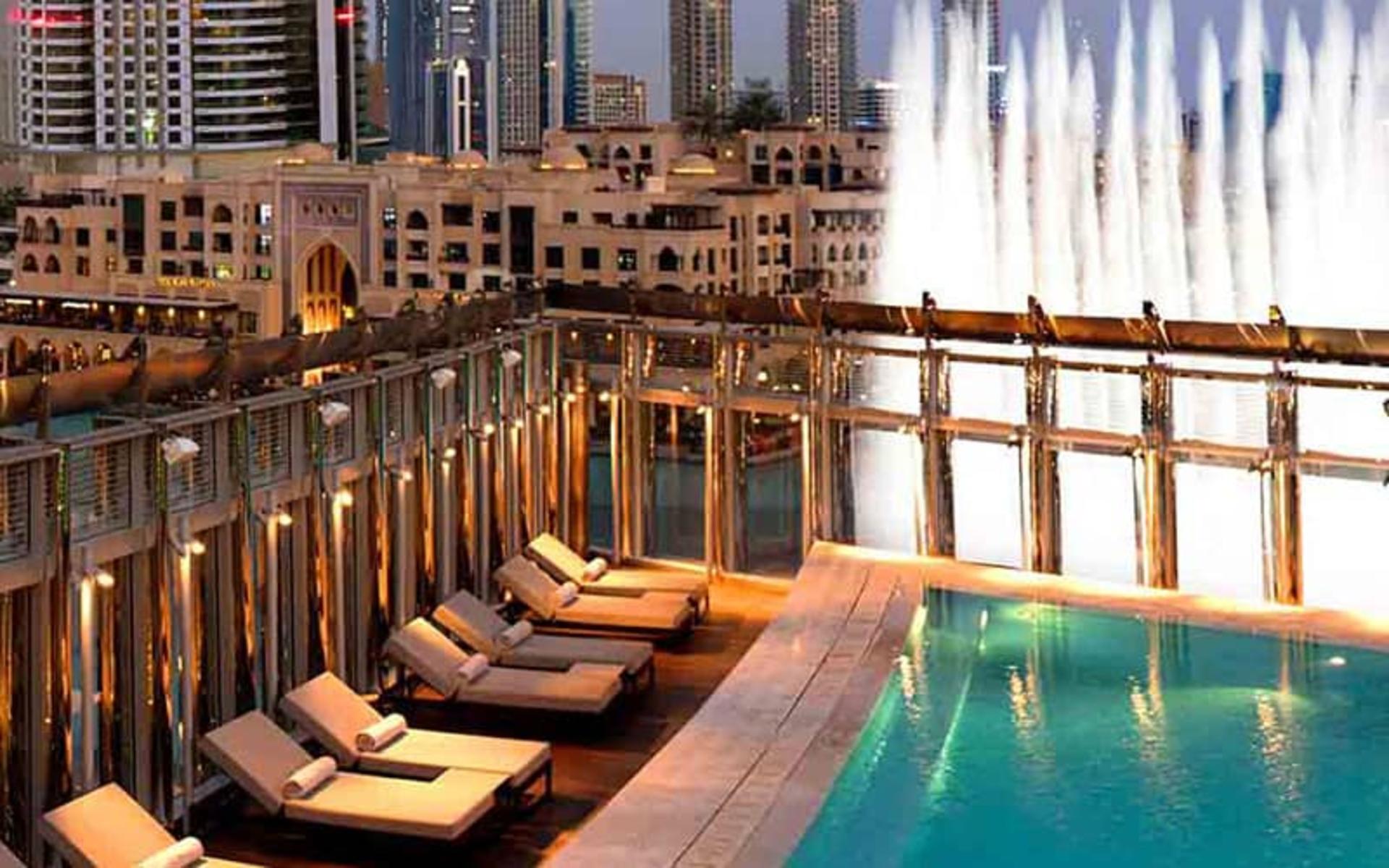 استخری در کنار فواره و دریاچه با تخت های استراحت