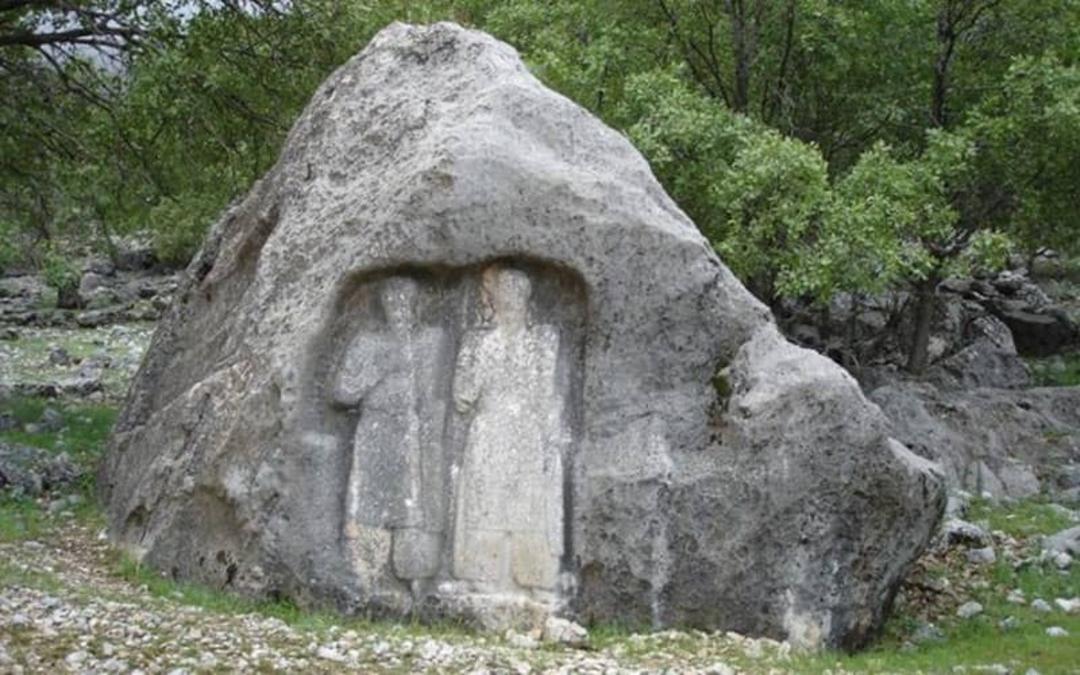 صخره ای با کنده کاری دو پیکره روی آن