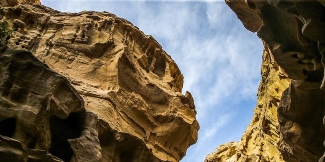 صخره های تودرتوی تنگه چاهکوه قشم زیر آسمان آبی