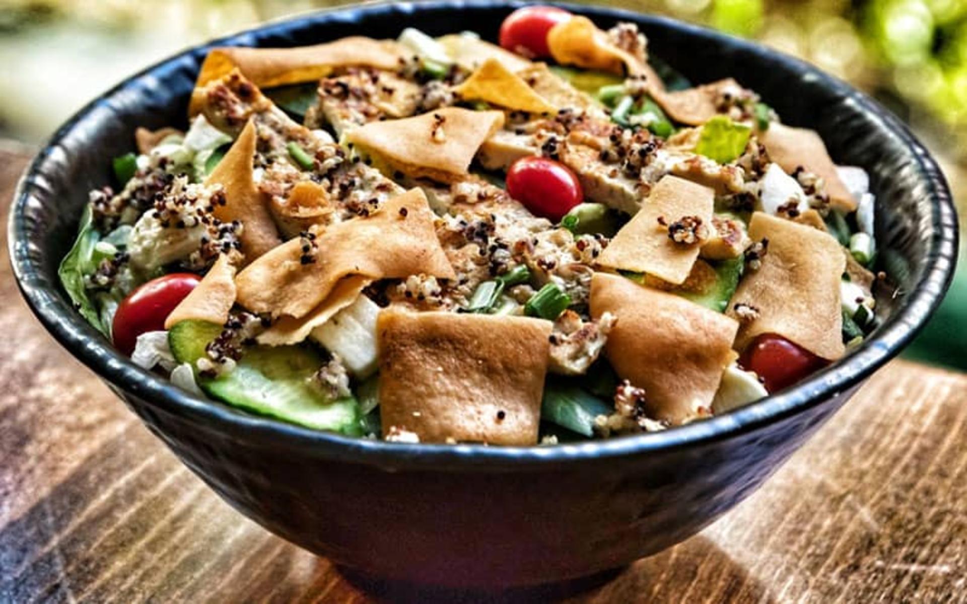 یک کاسه سالاد با خیار و گوجه گیلاسی و نان تست شده
