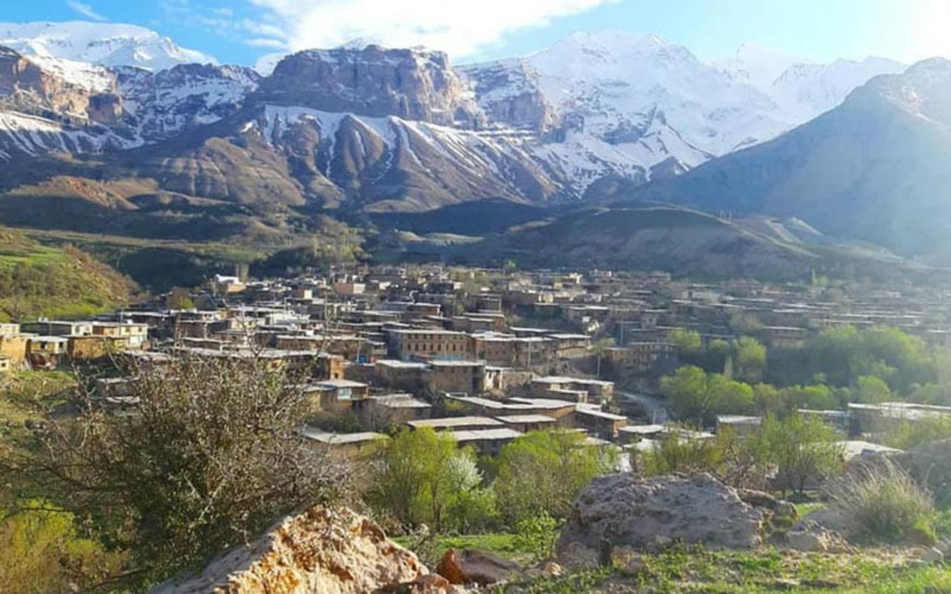 خانه های روستای خفر در دامنه کوهستان برفی خفر از نمای بالا