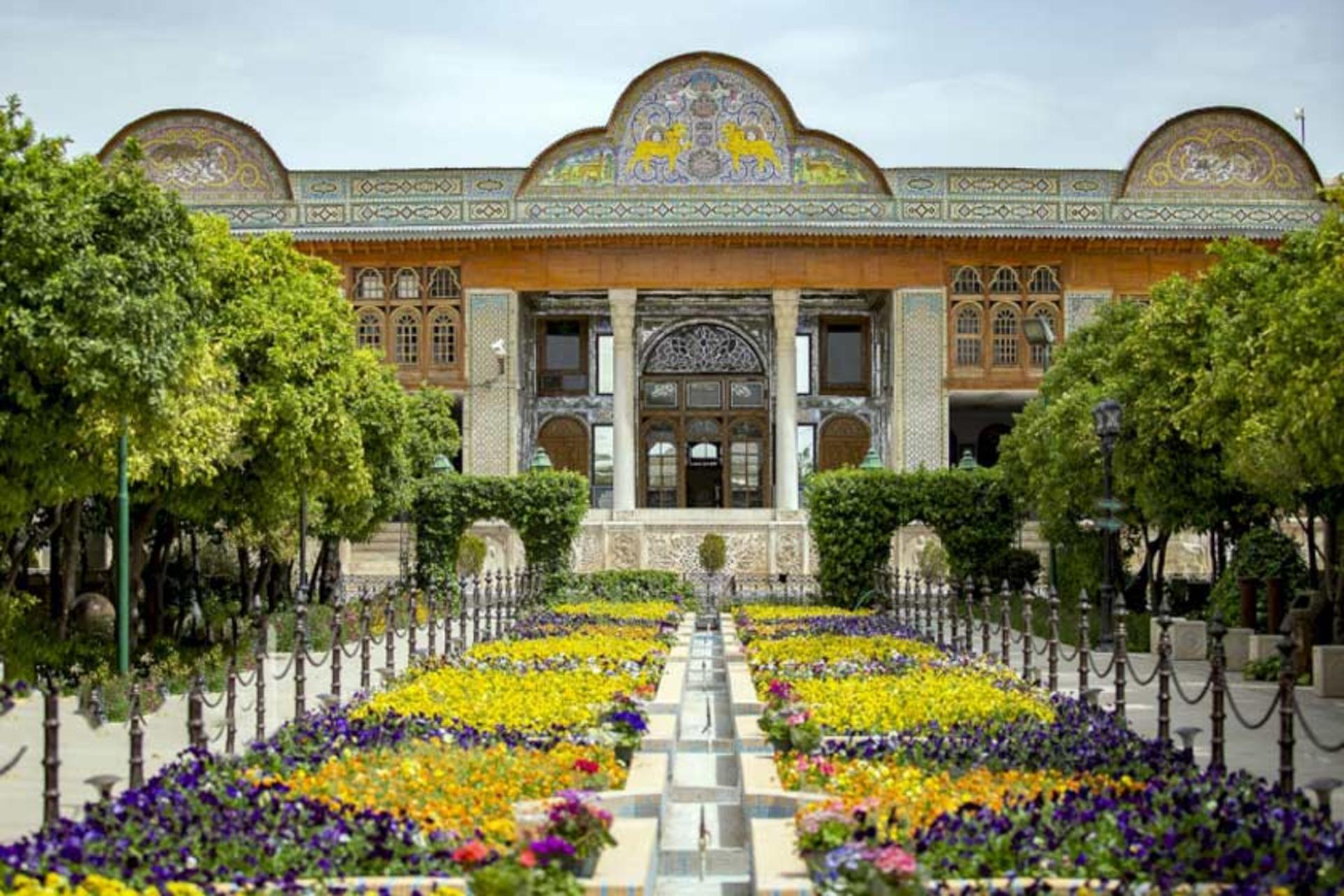 باغ ارم شیراز مقابل درختان سبز و گل کاری ها