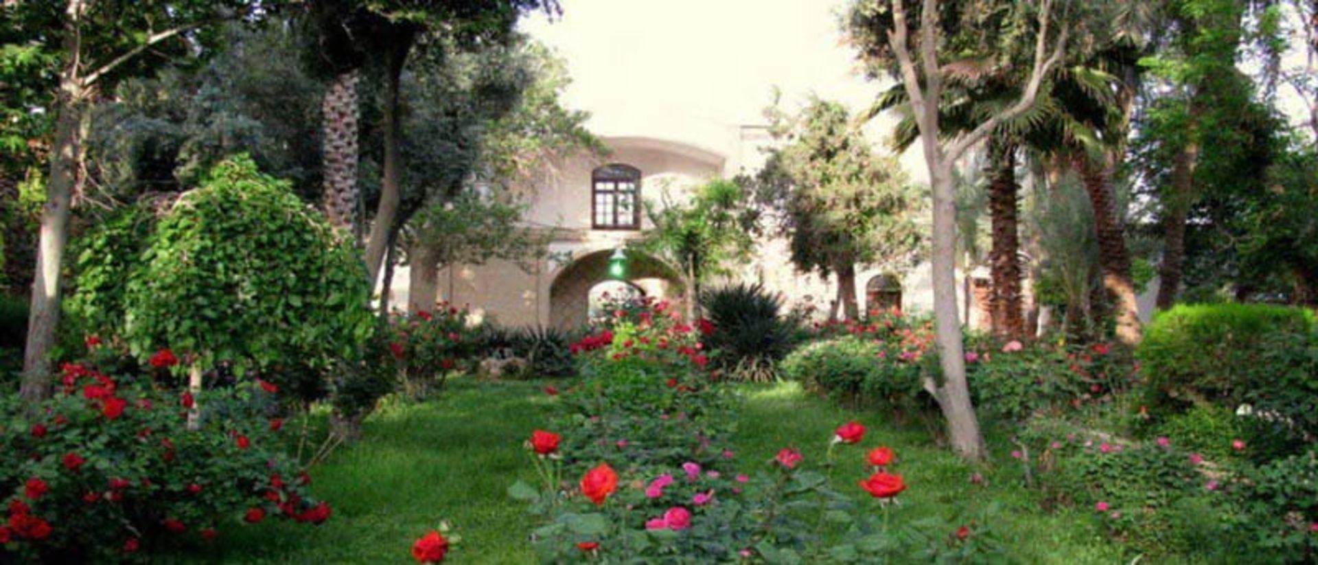 گل های قرمز و بنفش در باغ گلشن طبس مقابل عمارت باغ