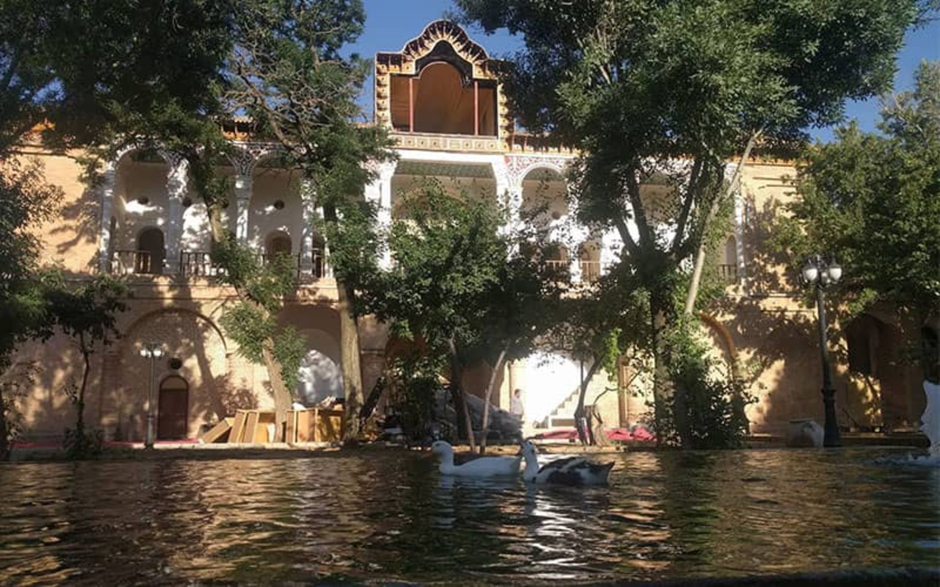 عمارتی بزرگ با حوض آبی در مقابل آن