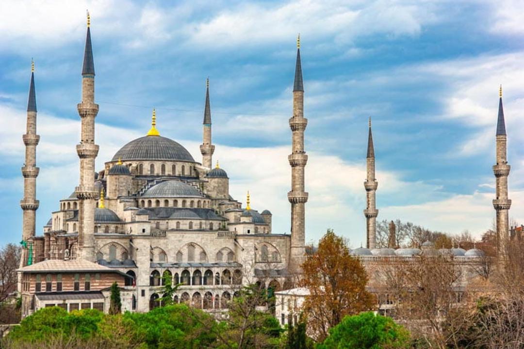 گنبد و گلدسته های مسجد سلطان احمد استانبول زیر آسمان آبی پر ابر