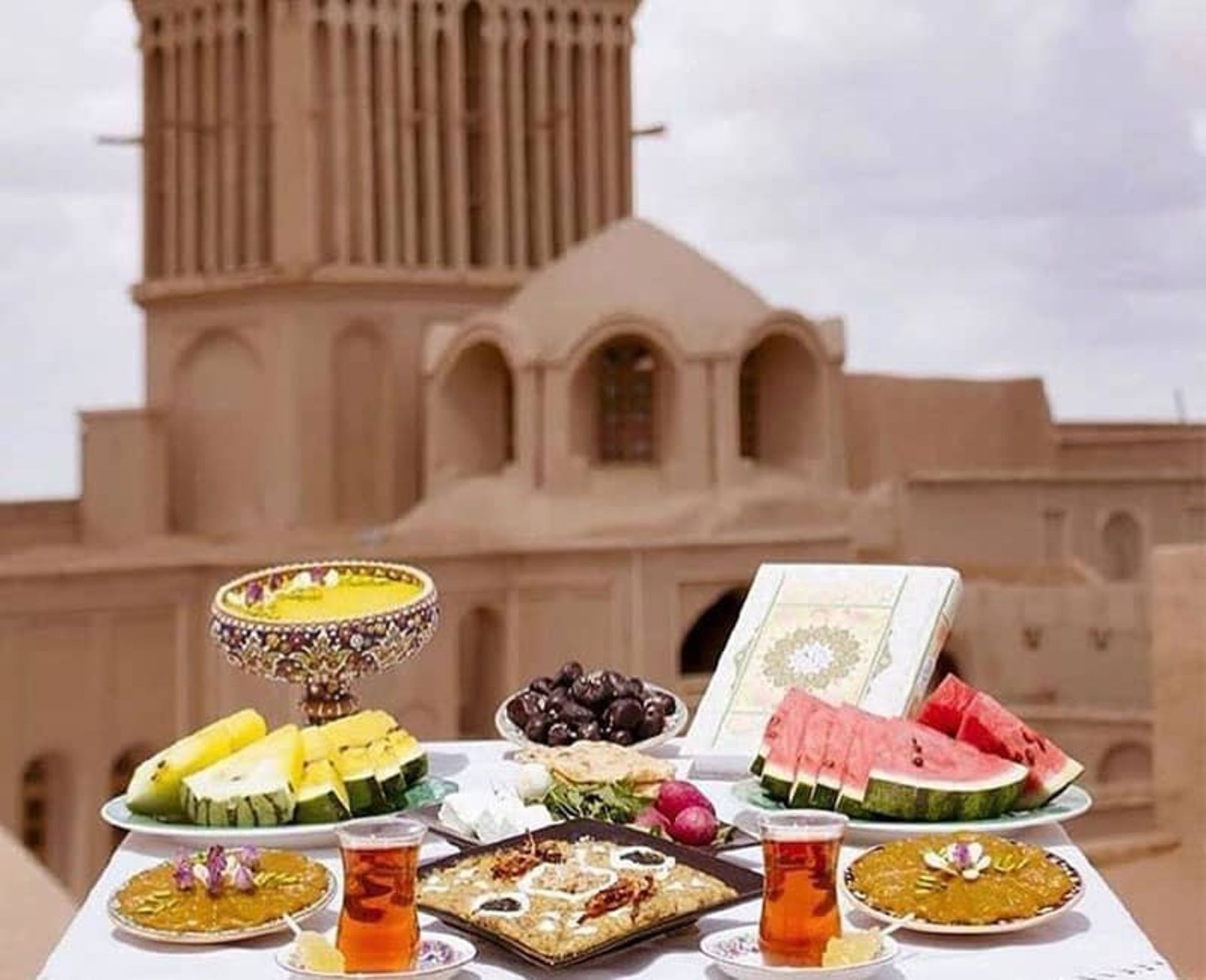 میز صبحانه در کنار عمارتی تاریخی با بادگیر